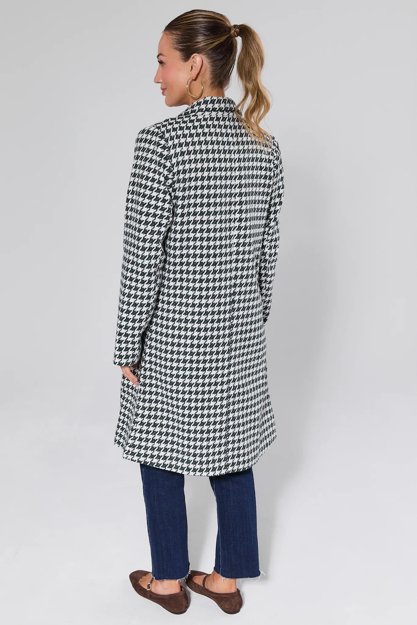 Woman wearing a Jonah Green Houndstooth Coat on a plain background