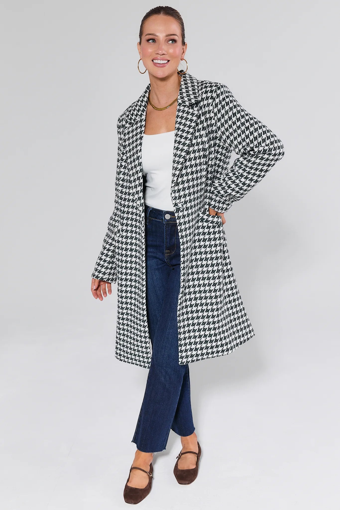 Woman wearing a Jonah Green Houndstooth Coat on a plain background