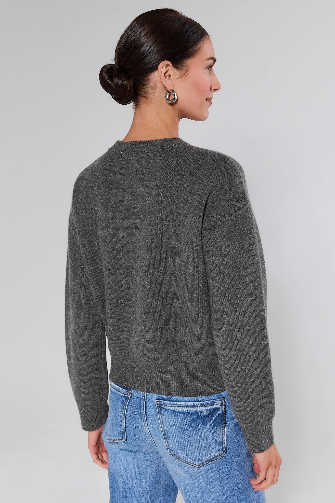 Woman wearing a Stella Grey Embellished Sweater on a plain background