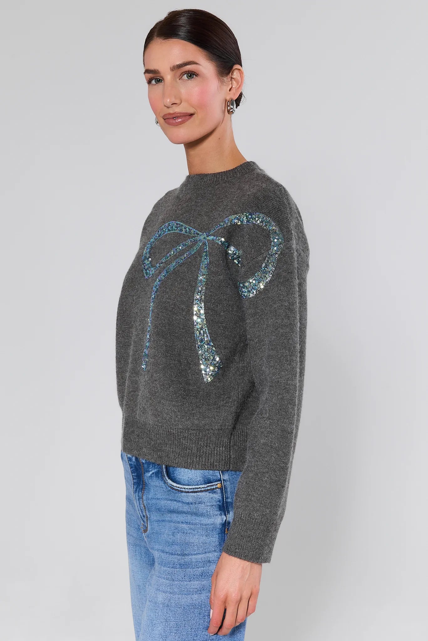 Woman wearing a Stella Grey Embellished Sweater on a plain background