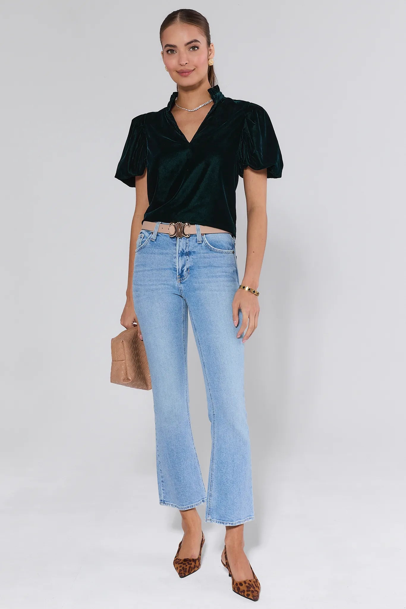 Woman wearing a Lynette Green Velvet Puff Sleeve Top against a plain background