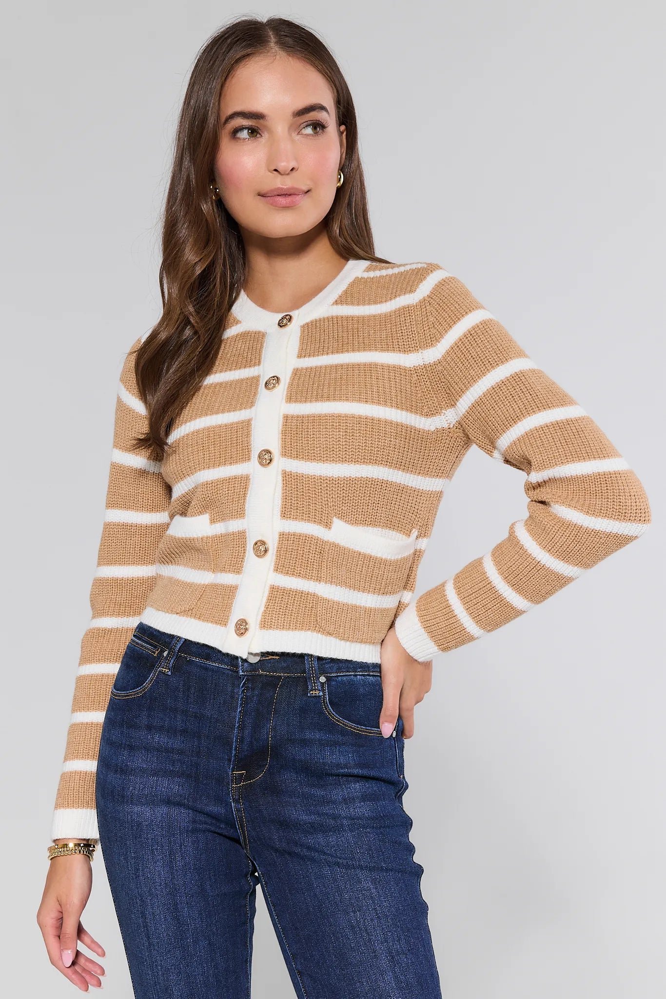 Woman wearing a striped Dayna Cardigan  and jeans against a plain background