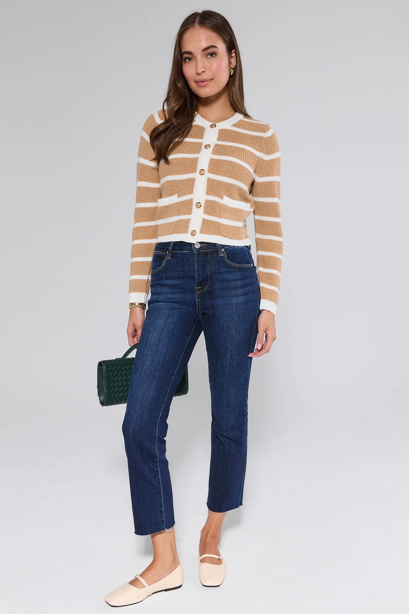 Woman wearing a striped Dayna Cardigan  and blue jeans on a white background