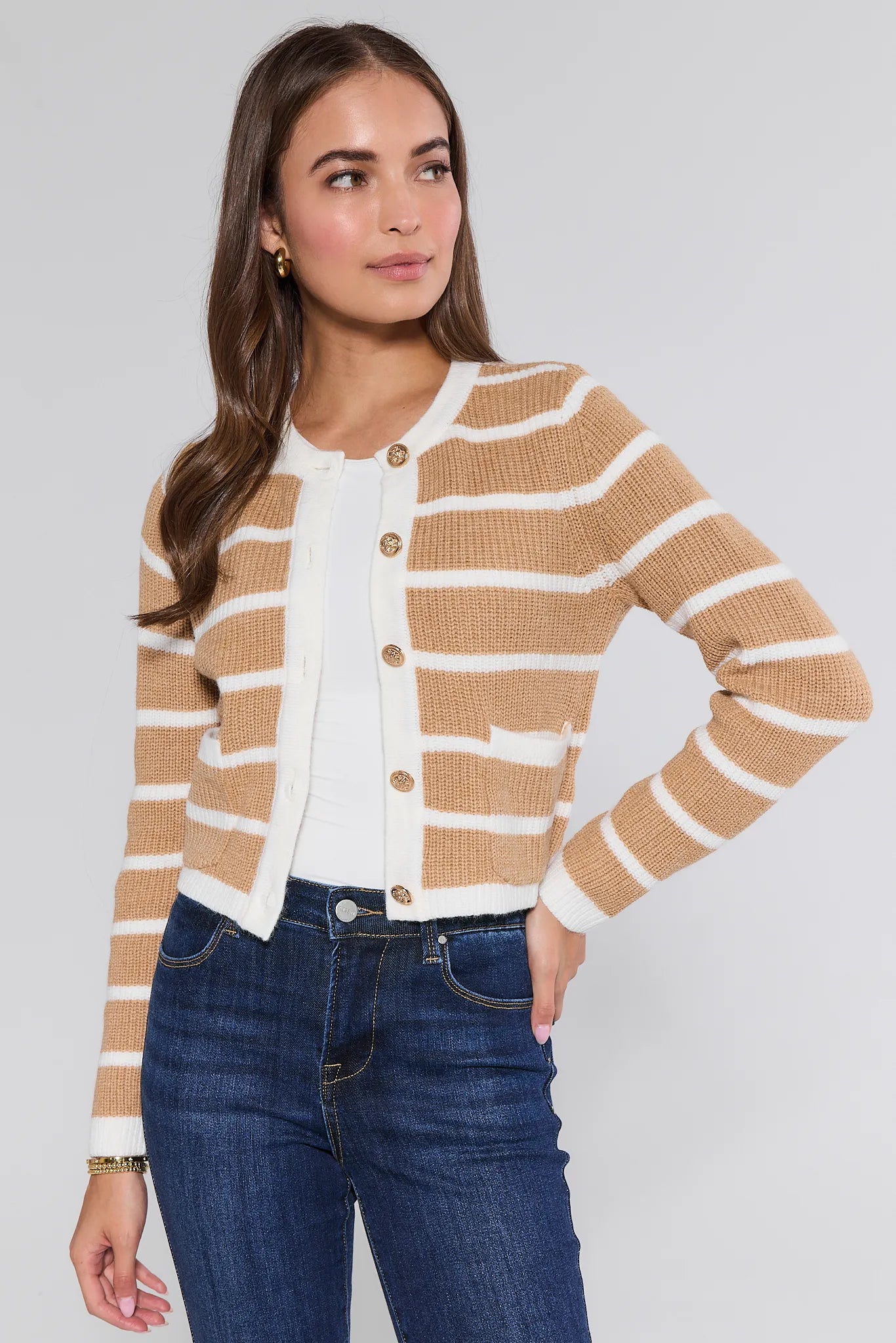 Woman wearing a striped Dayna Cardigan and jeans on a plain background