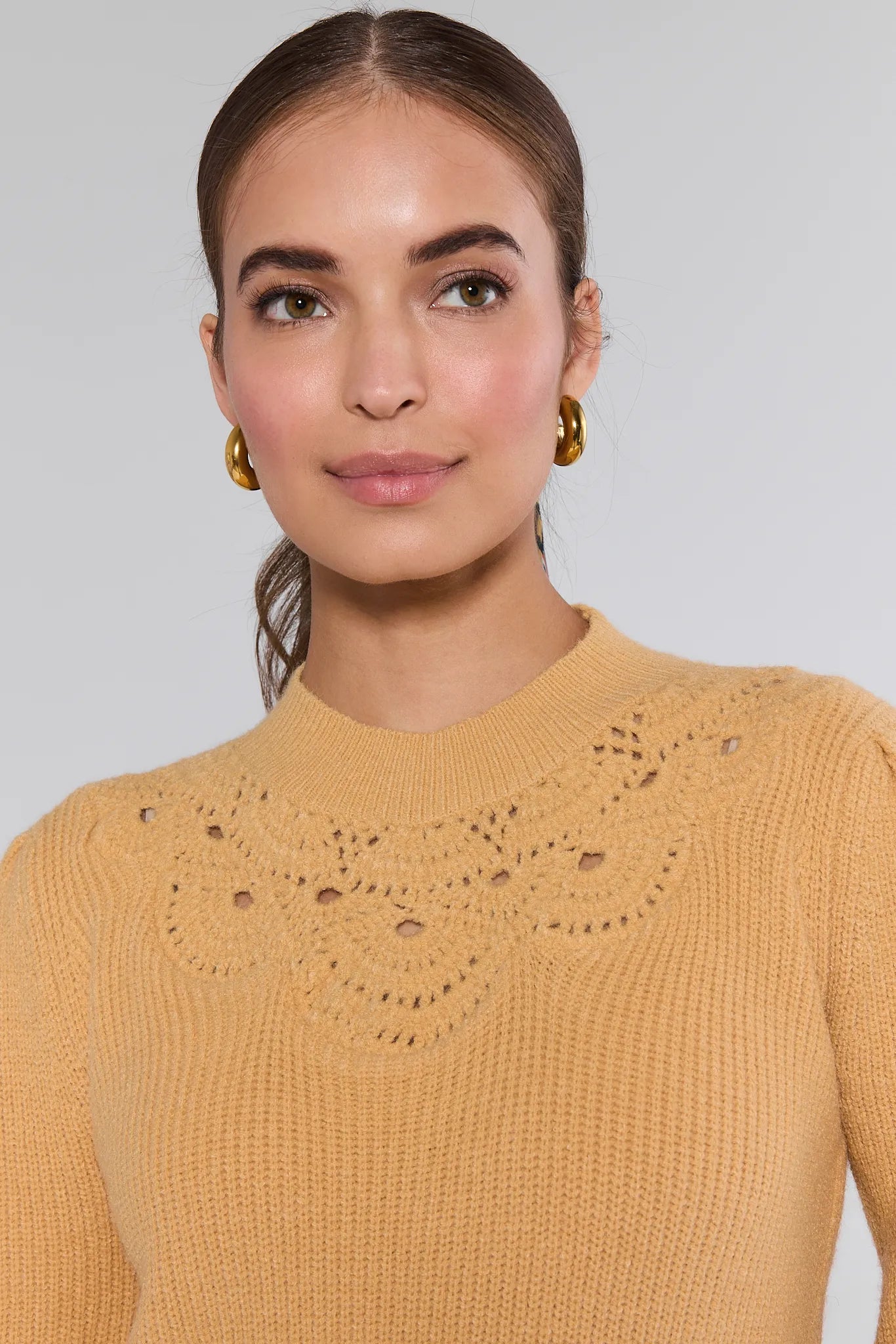 Woman wearing a yellow Dixie Sweater with intricate collar design against a plain background