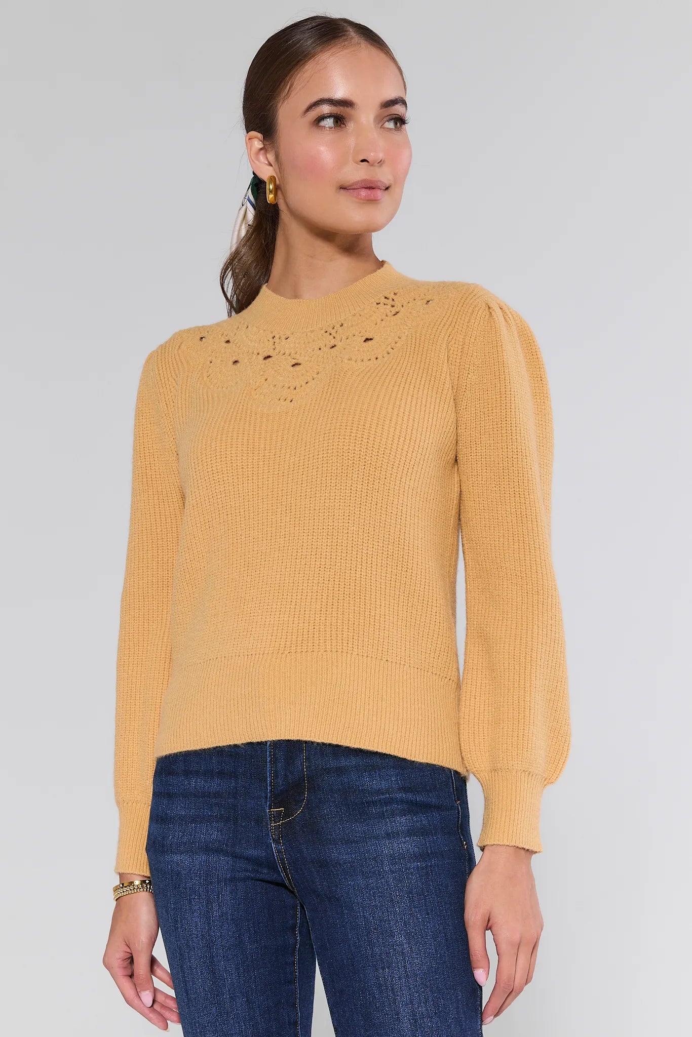 Woman wearing a yellow Dixie Sweater
 with lace details on a plain background