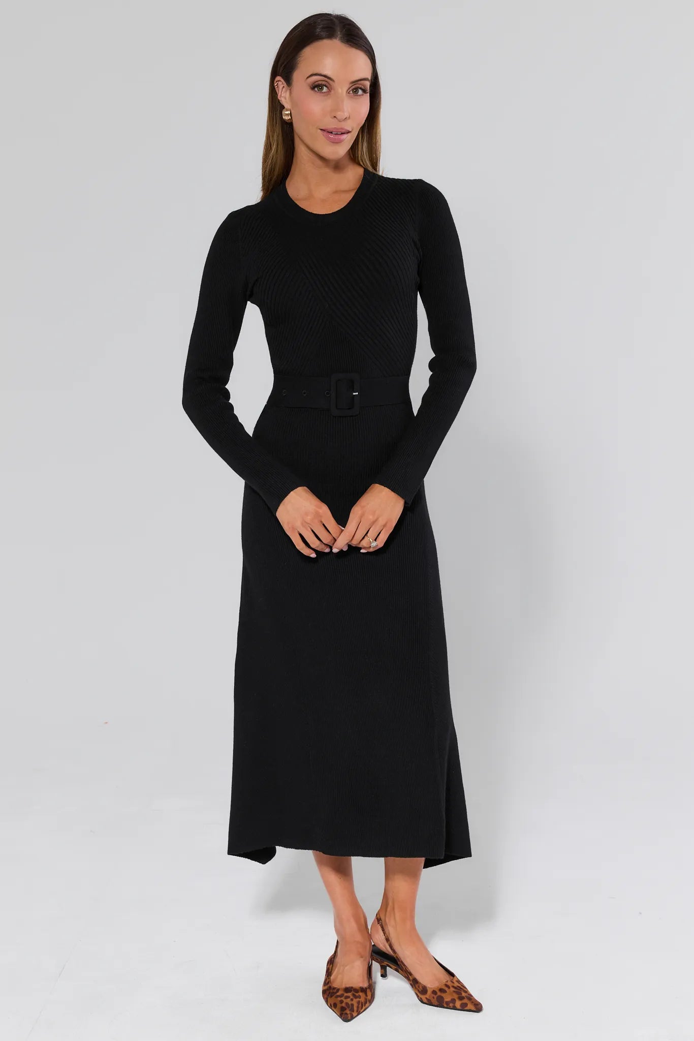 Woman wearing a Massey Black Knit Midi Dress and leopard heels on a white background