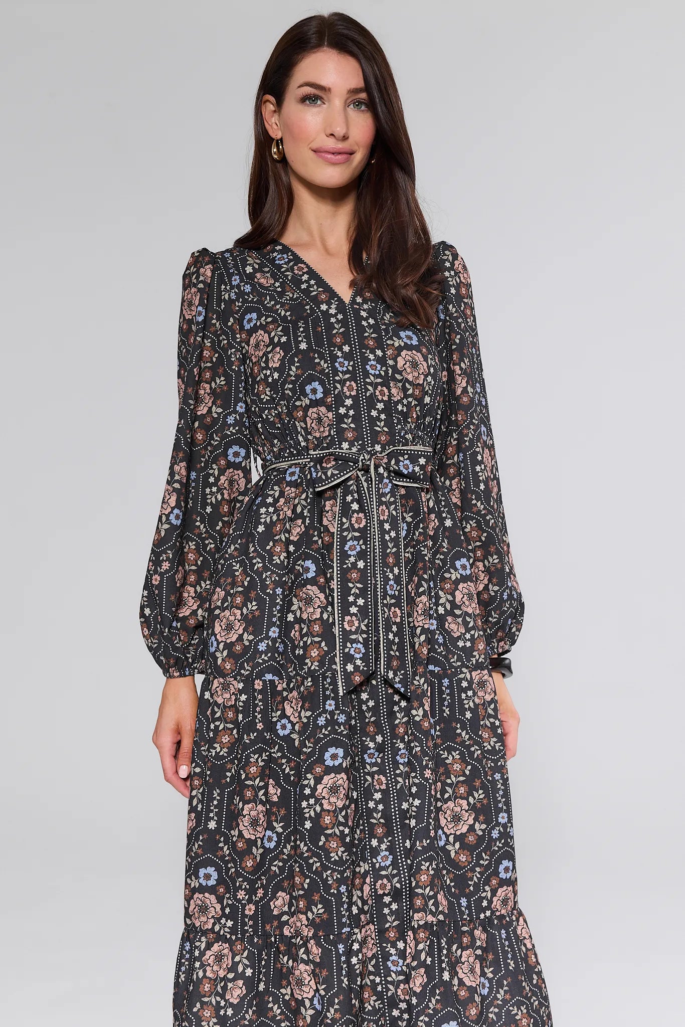 Woman wearing a floral patterned Bowen Dress on a plain background