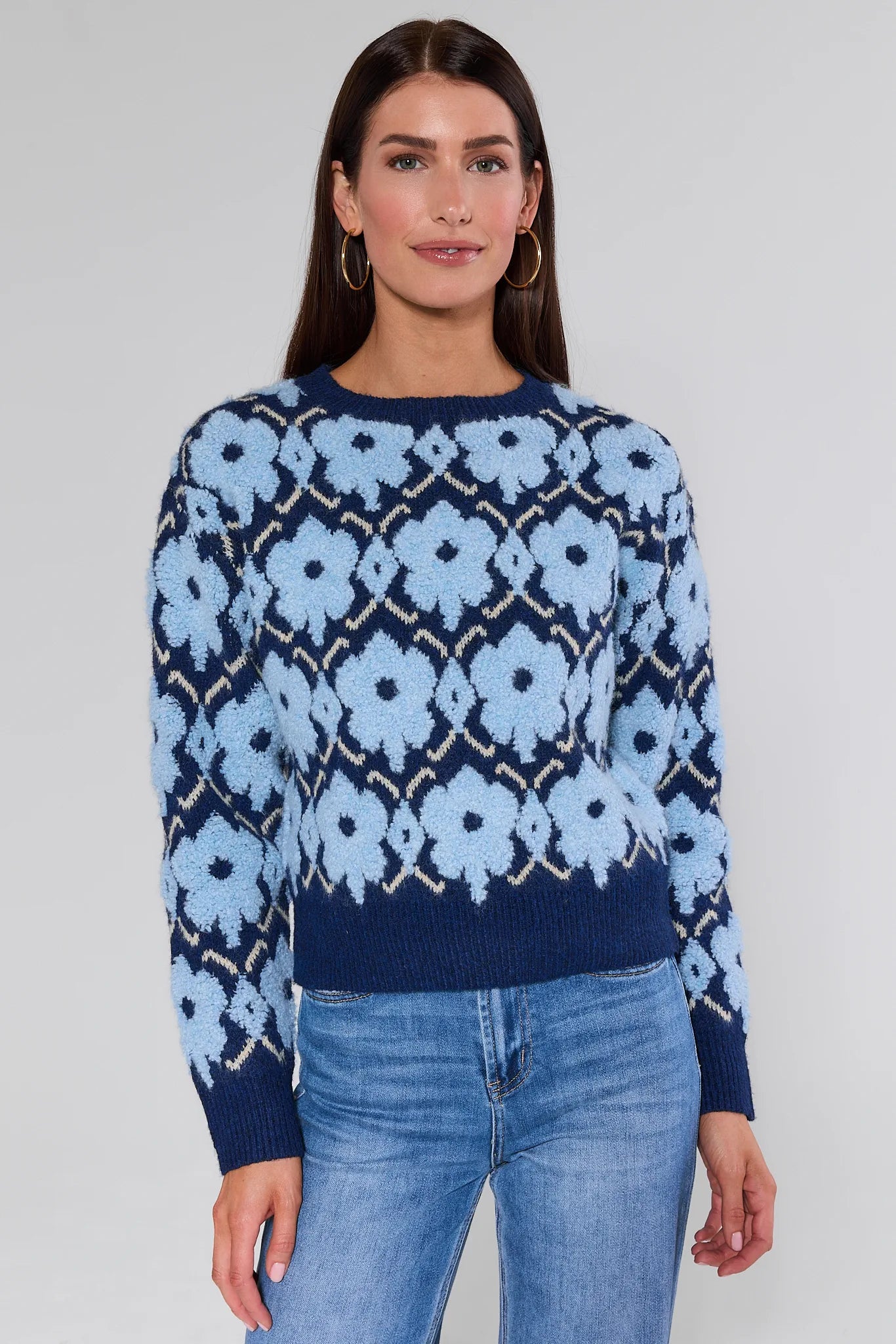 Woman wearing a Brynn Blue Floral Knit Sweater against a white background