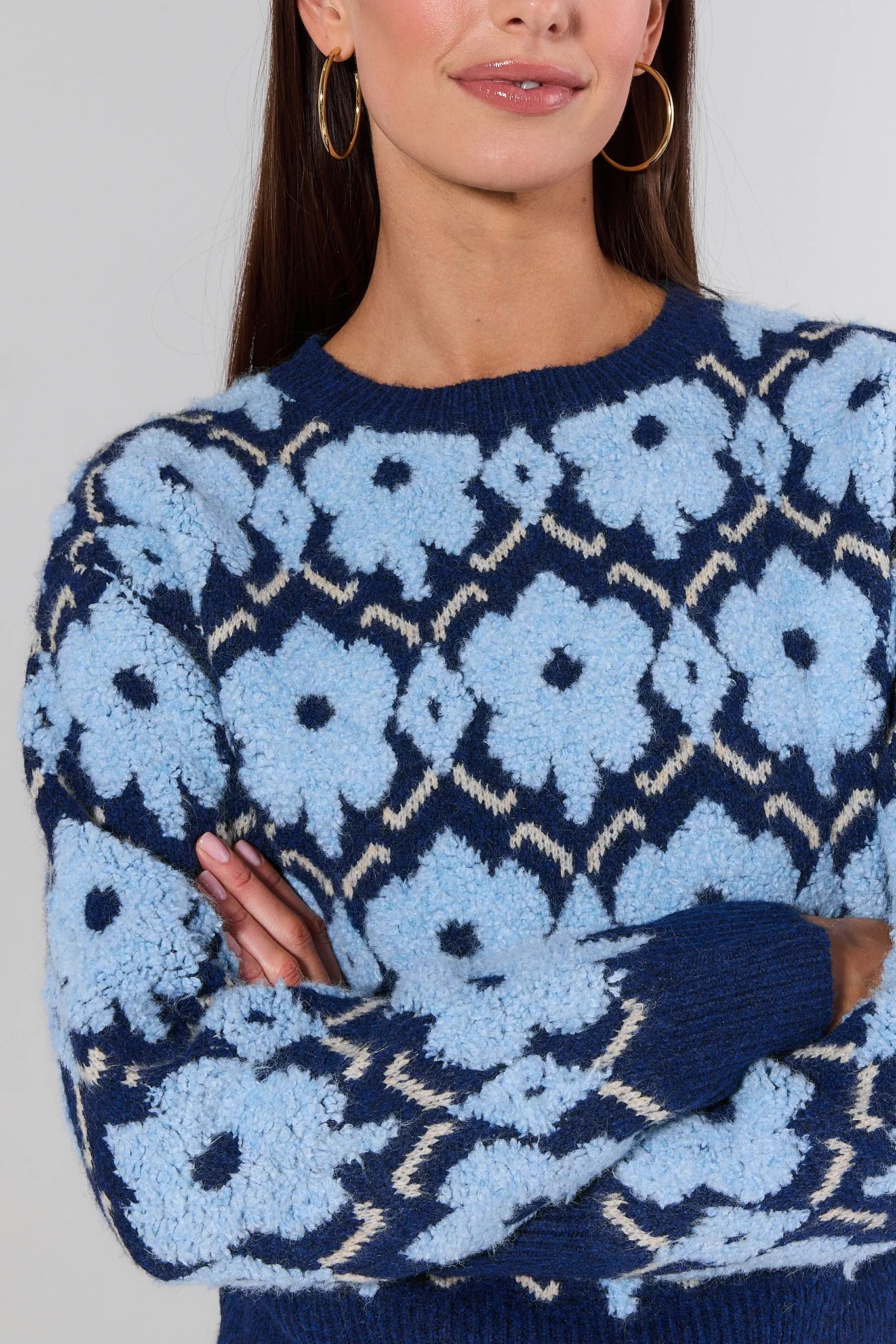 Woman wearing a Brynn Blue Floral Knit Sweater against a white background