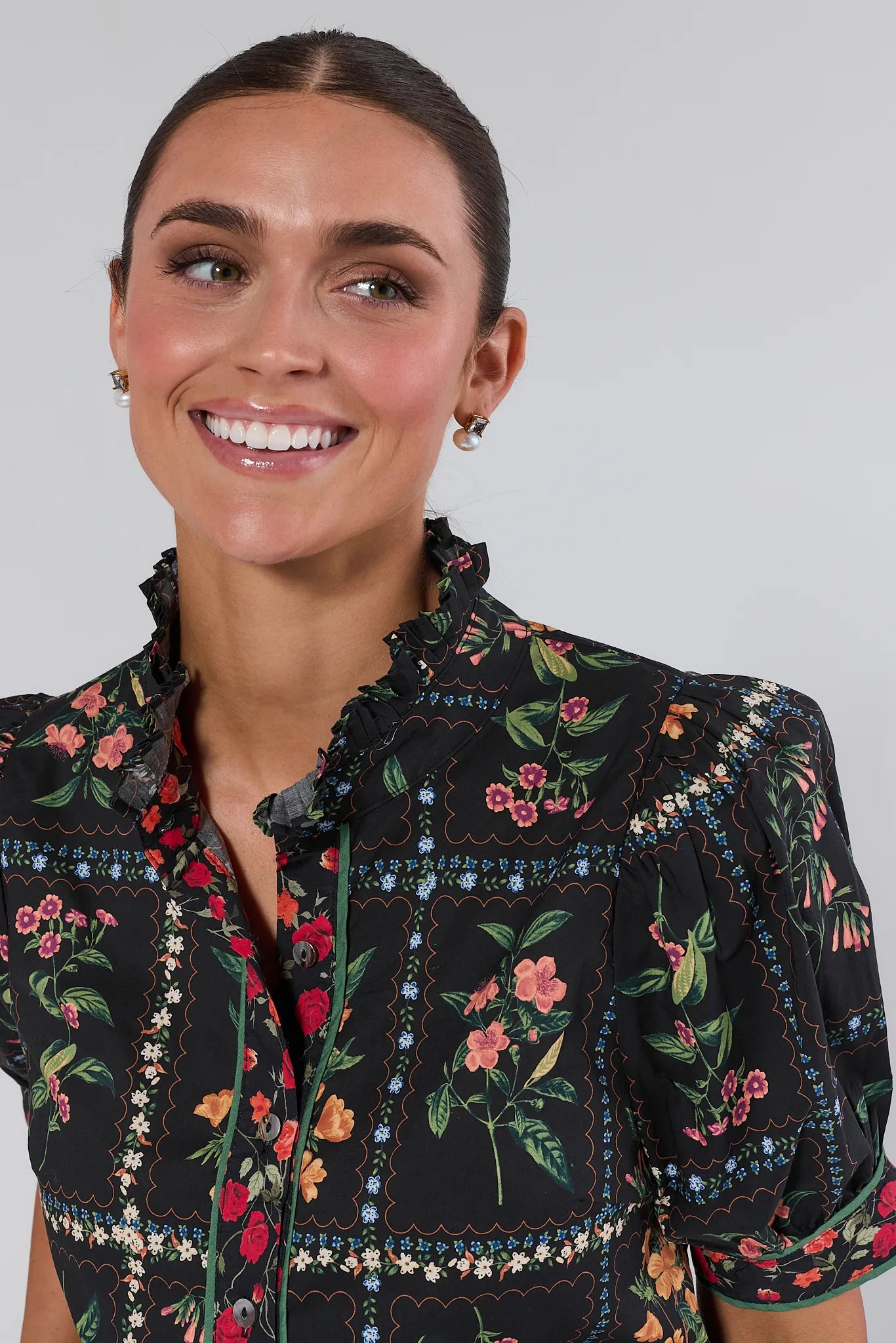 Woman wearing a black floral embroidered Adele Top against a plain background