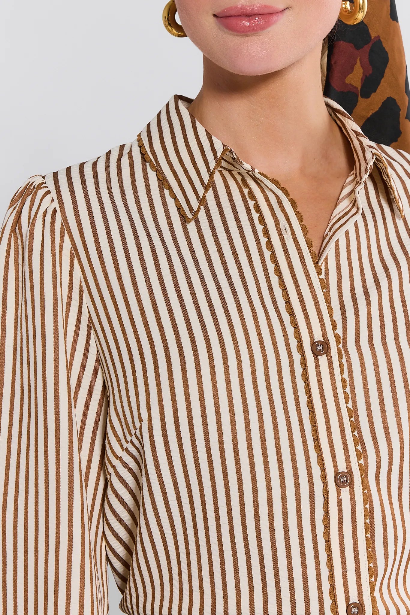 Close-up of a person wearing a brown and white striped Levi Top.