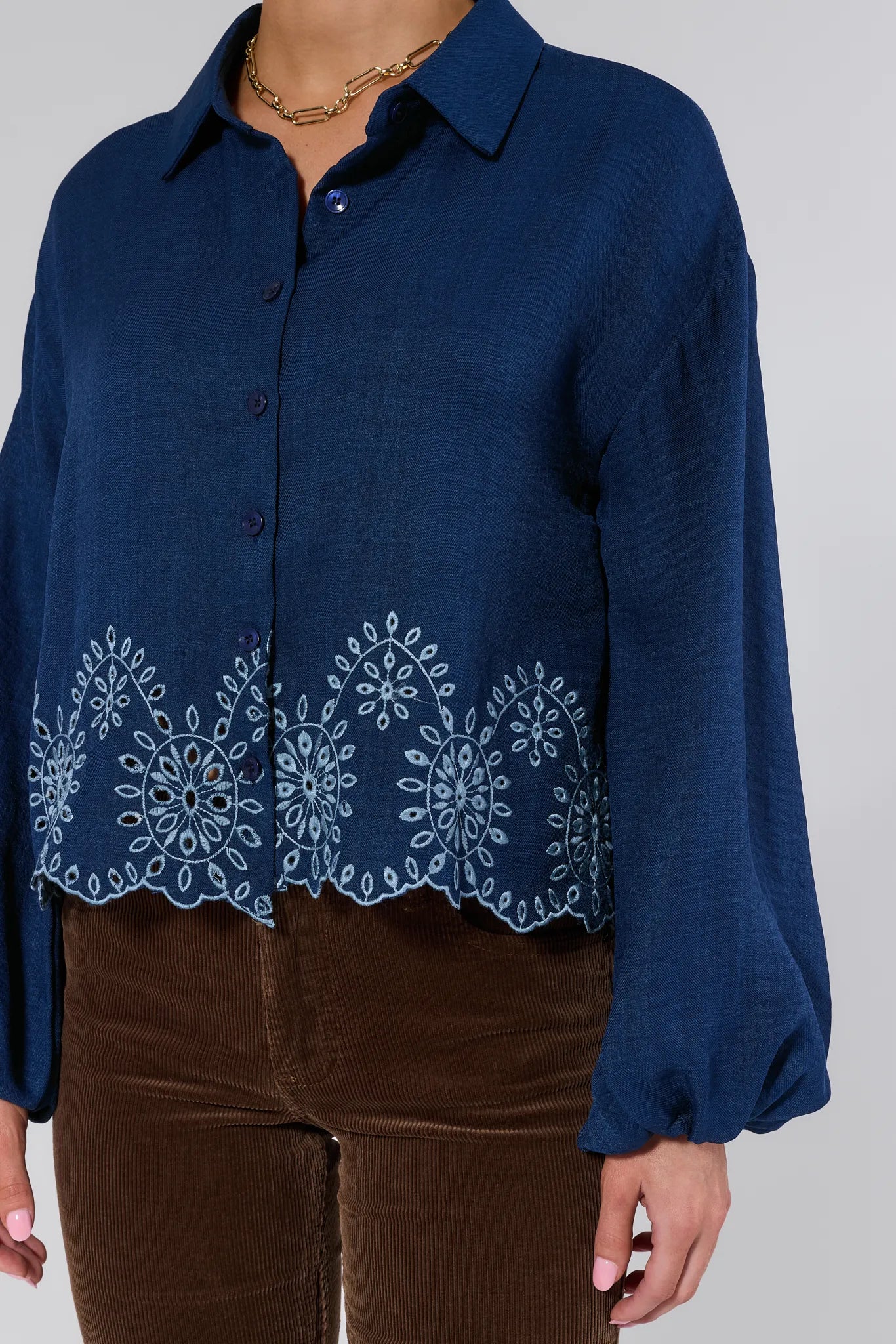 Navy blue Micah Top with white embroidery on a plain background