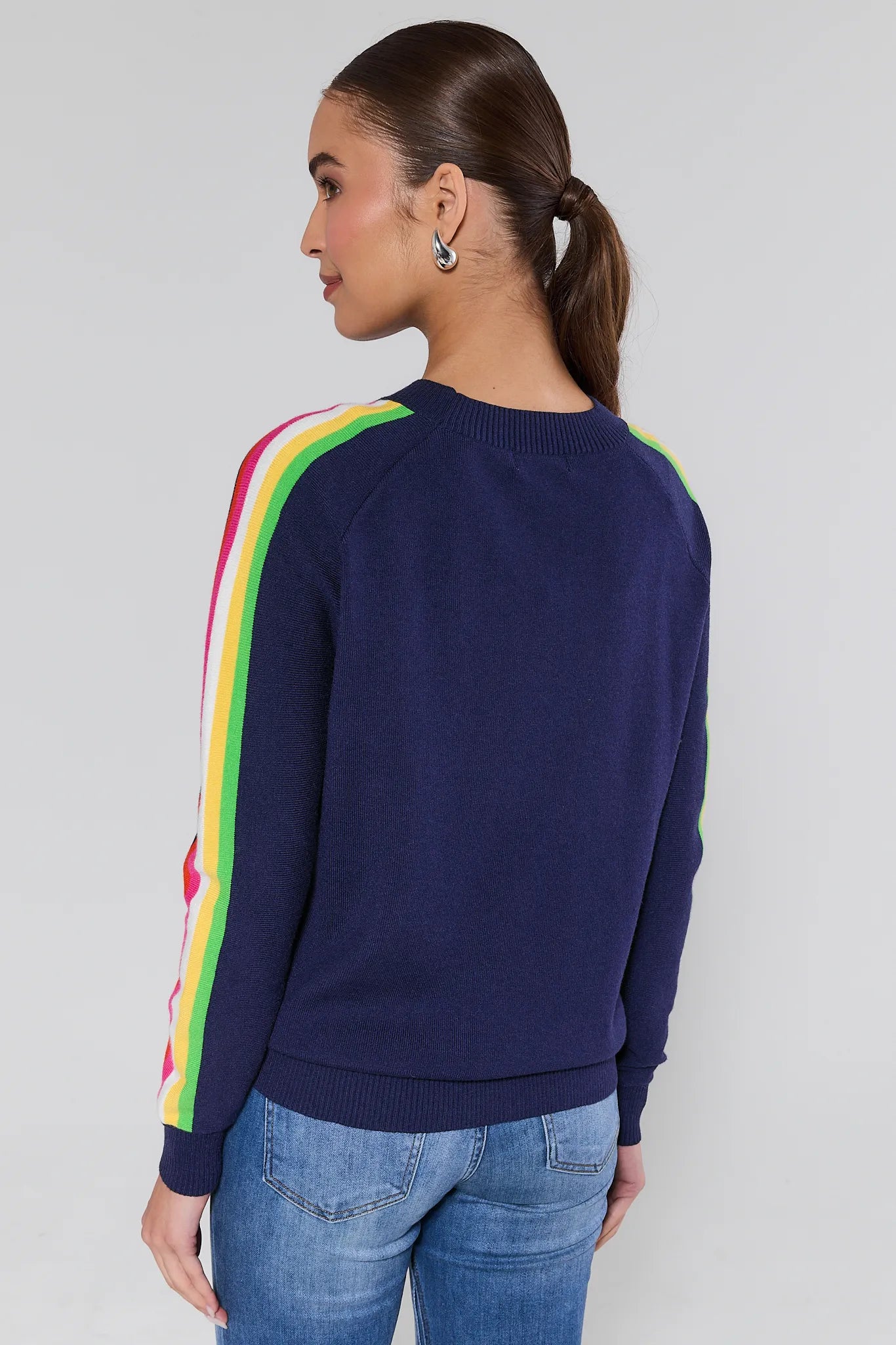 Woman wearing a navy sweater with colorful stripes on a plain background Khloe Navy Striped Sleeve Sweater