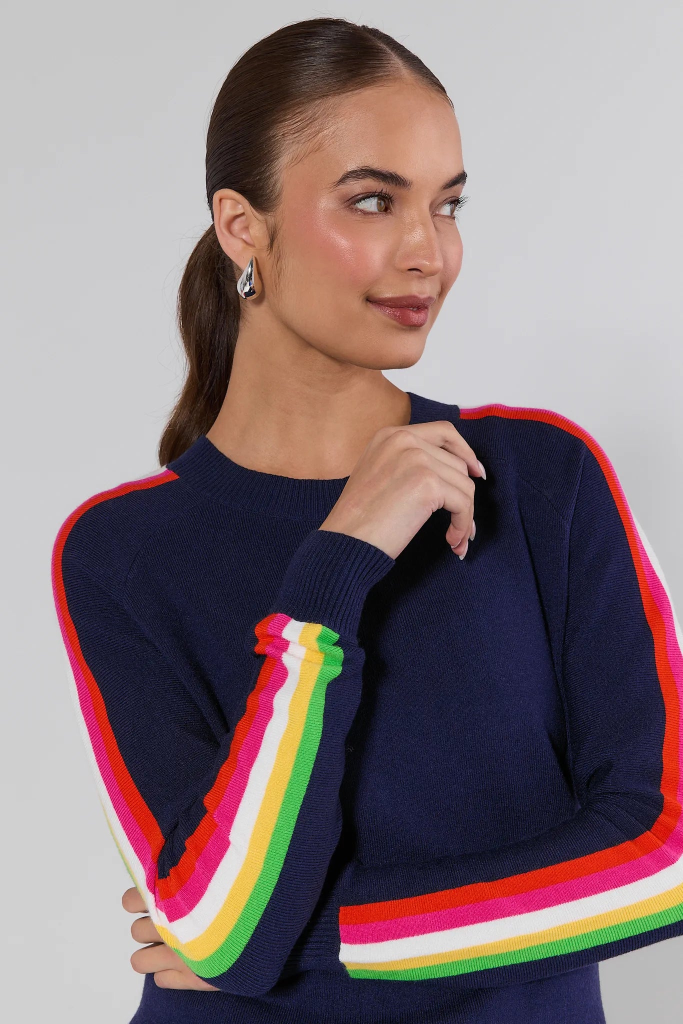 Woman wearing a navy sweater with colorful stripes on a plain background Khloe Navy Striped Sleeve Sweater
