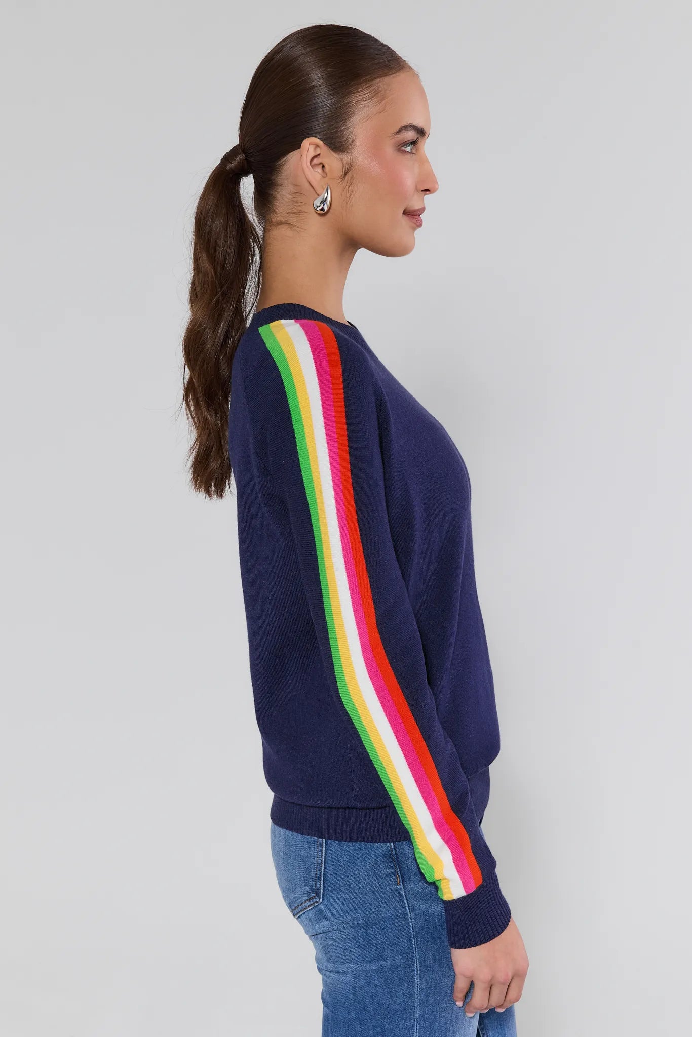 Woman wearing a navy sweater with colorful stripes on a plain background Khloe Navy Striped Sleeve Sweater