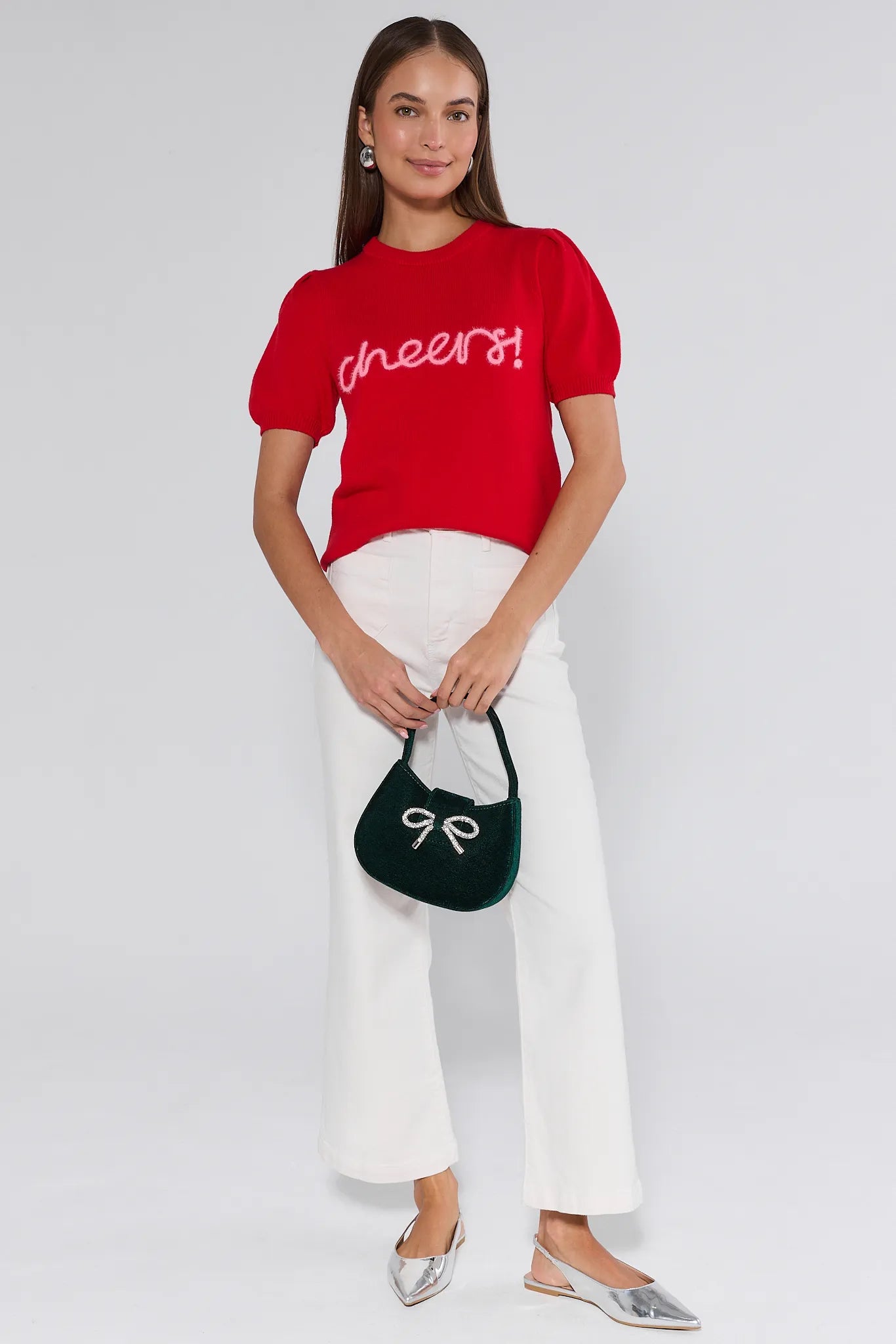 Woman wearing a red sweater with 'cheers' text on a plain background