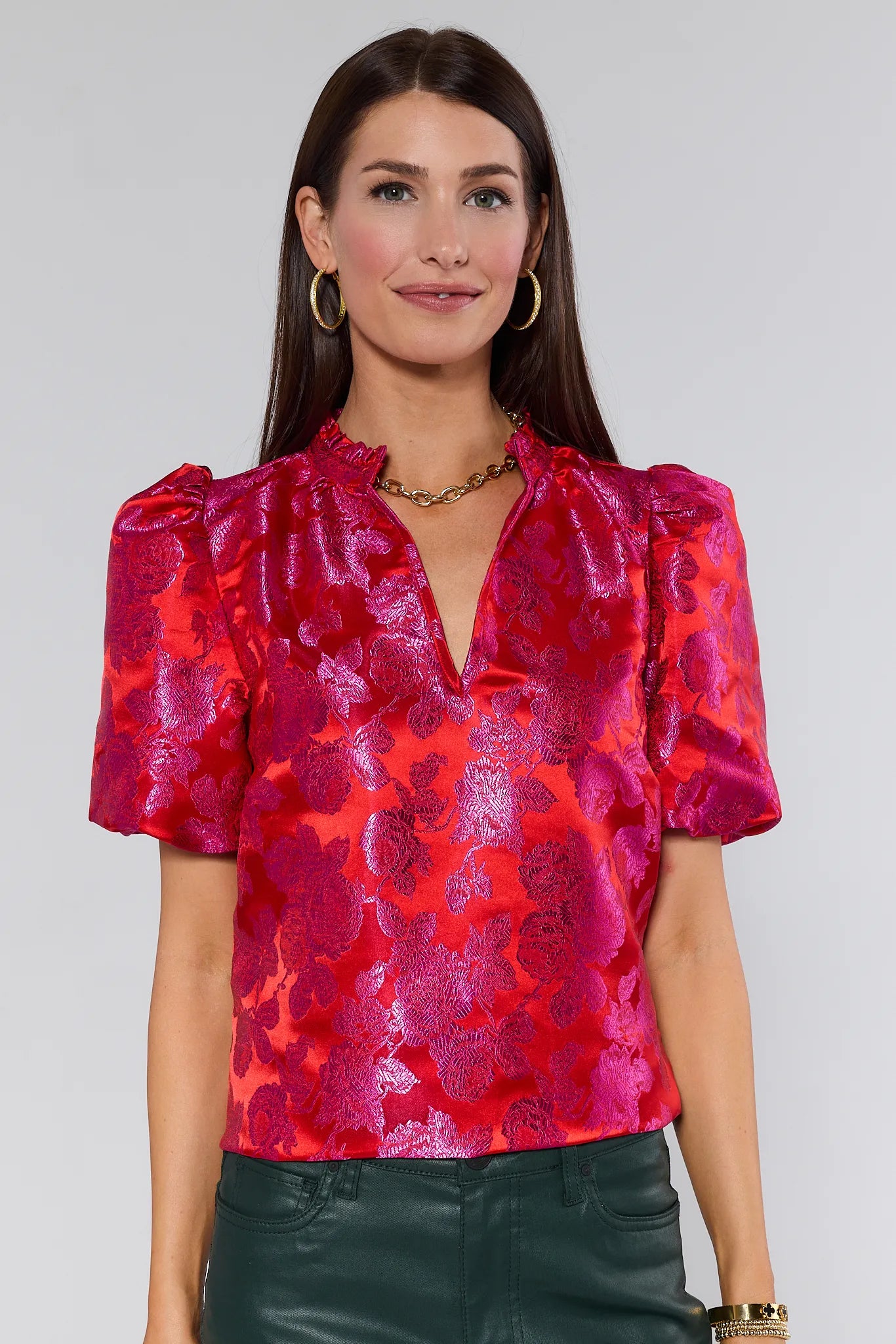 Woman wearing a red Alyssa Brocade Puff Sleeve Top against a gray background