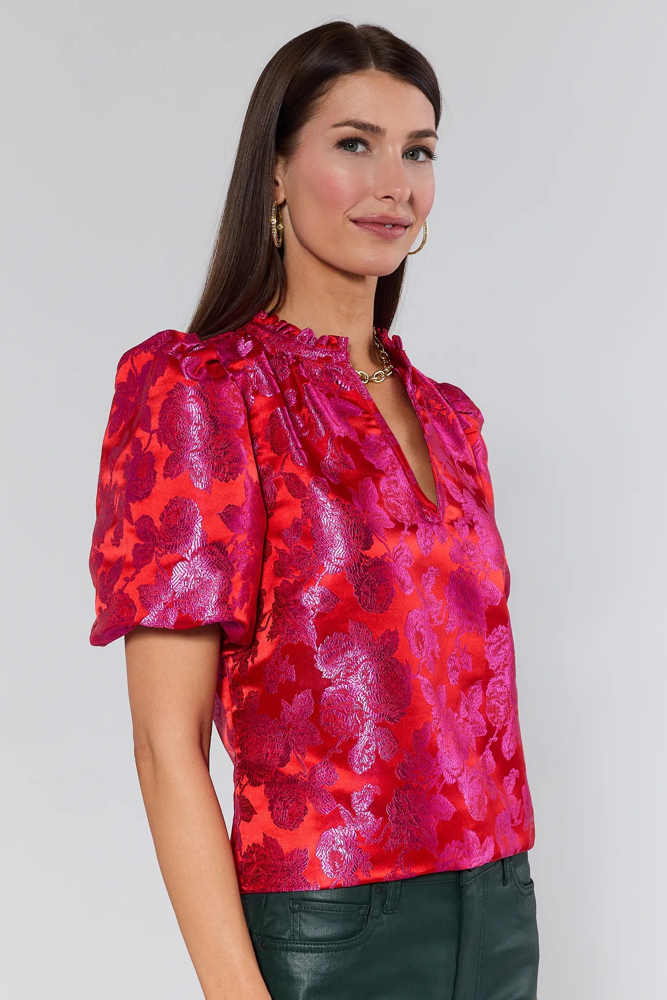 Woman wearing a red Alyssa Brocade Puff Sleeve Top against a gray background