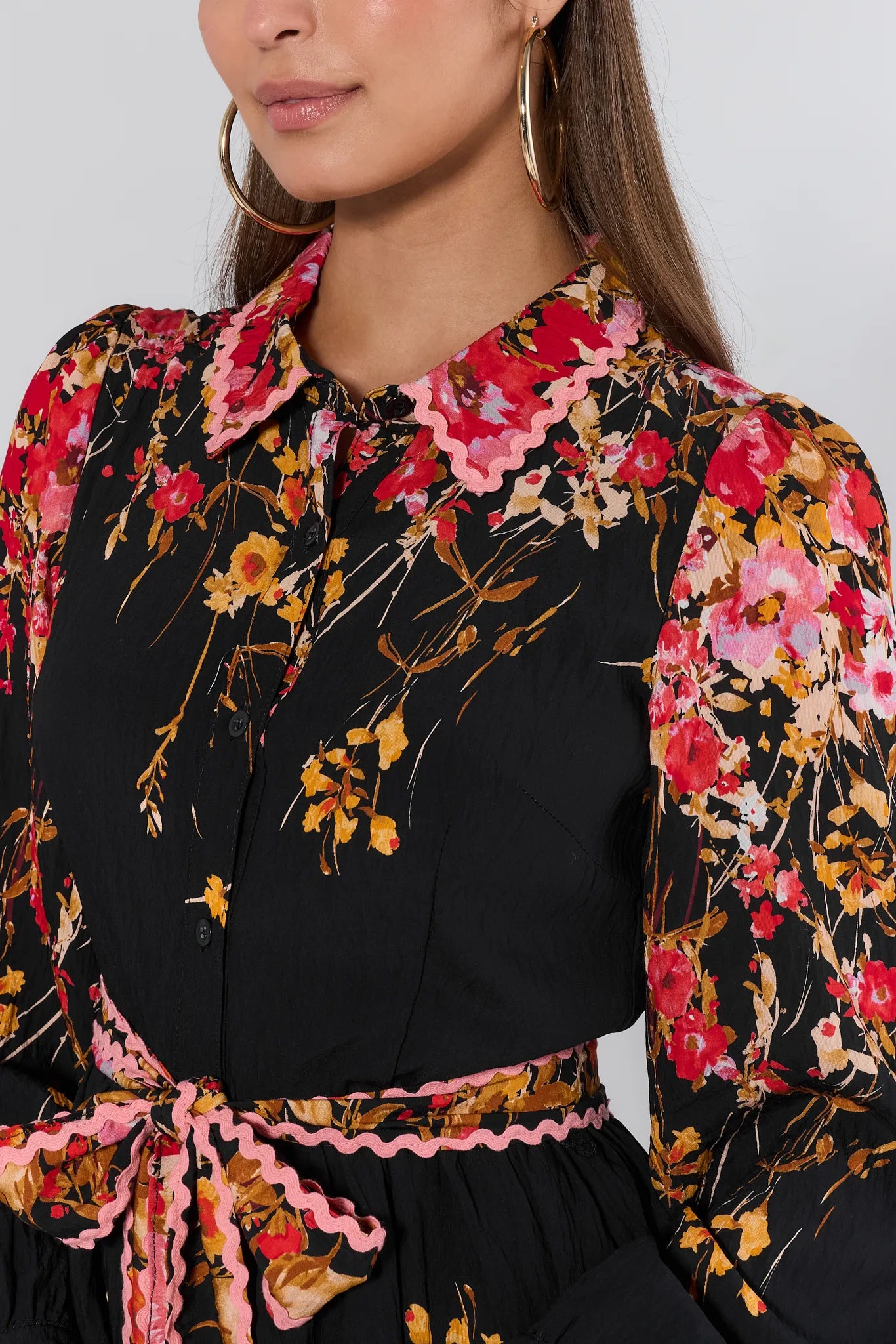 Woman wearing a black Faye Dress with colorful floral patterns on a white background