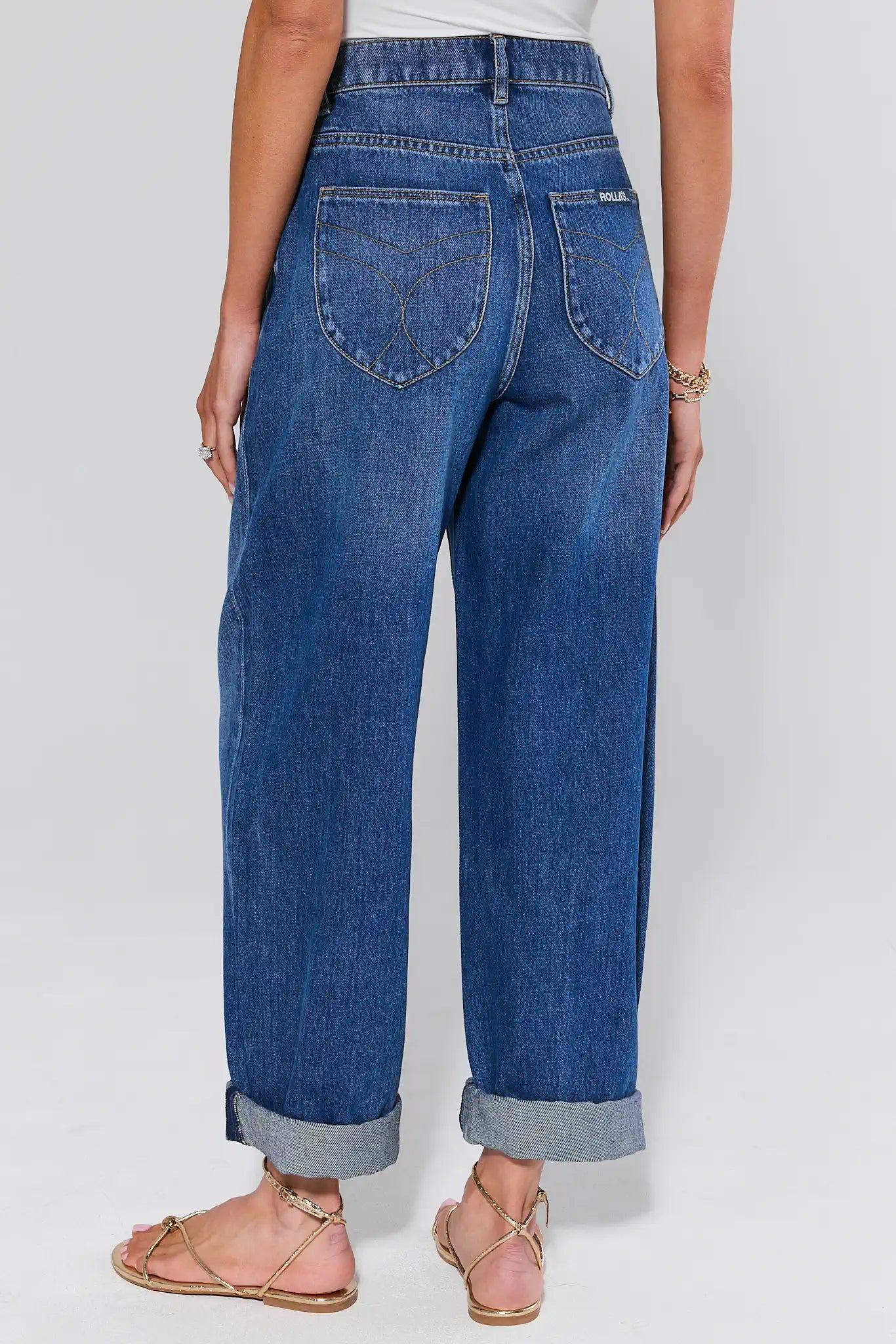 Person wearing blue jeans on a plain background