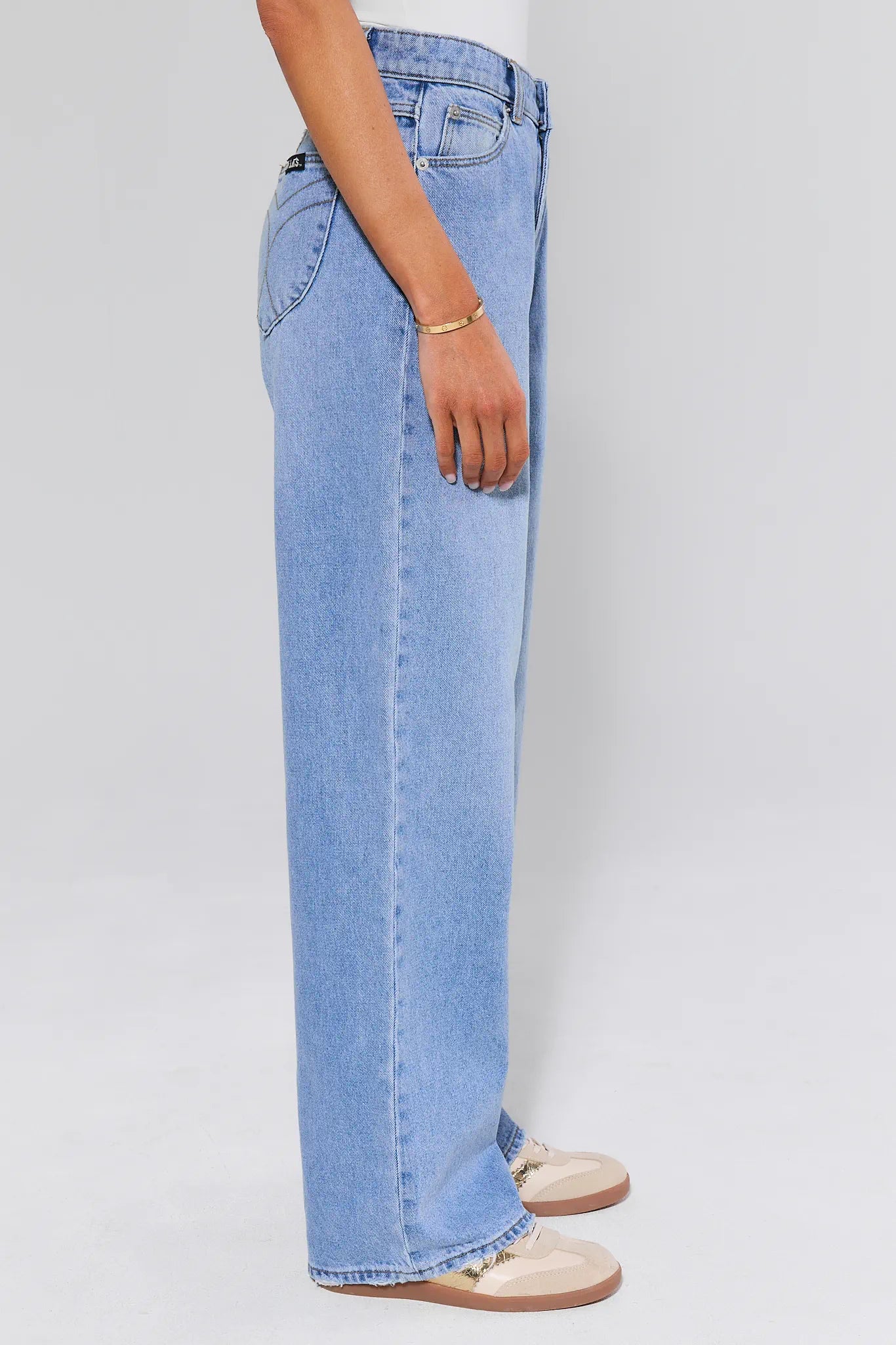 Light blue jeans worn by a person on a plain background