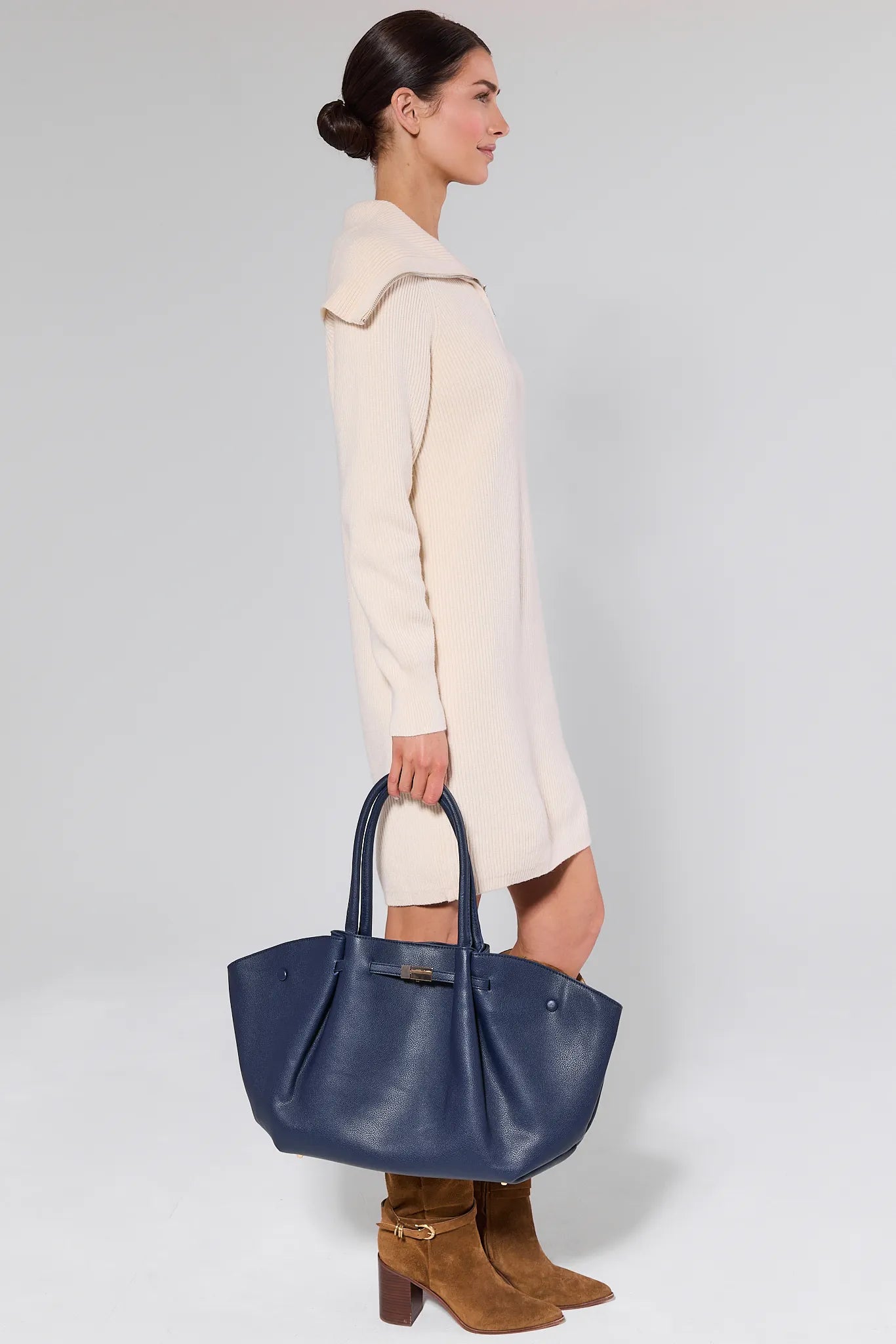 Woman holding a blue handbag against a white background Kyra Navy Faux Leather Bag