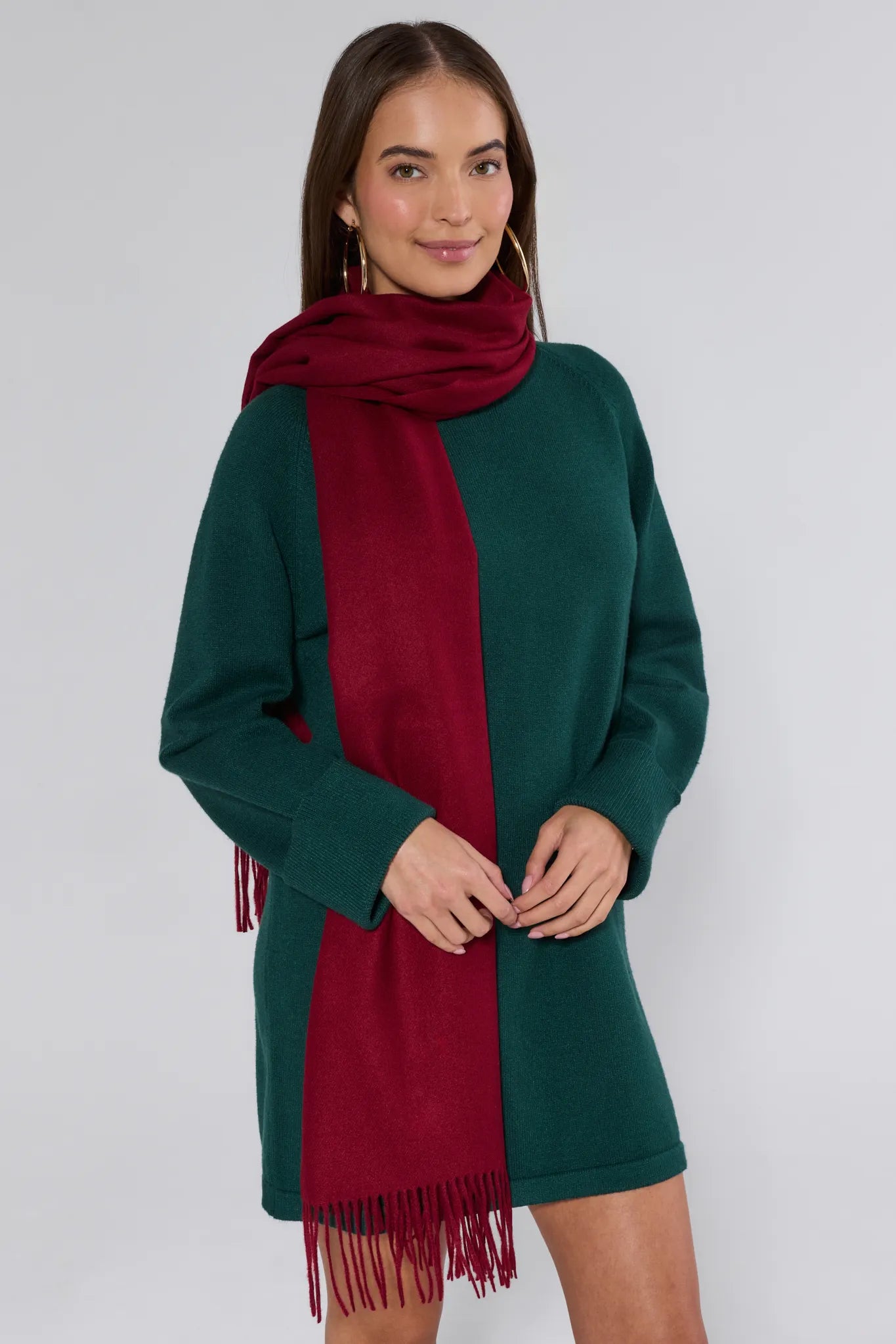 Woman wearing a green dress and red scarf on a white background