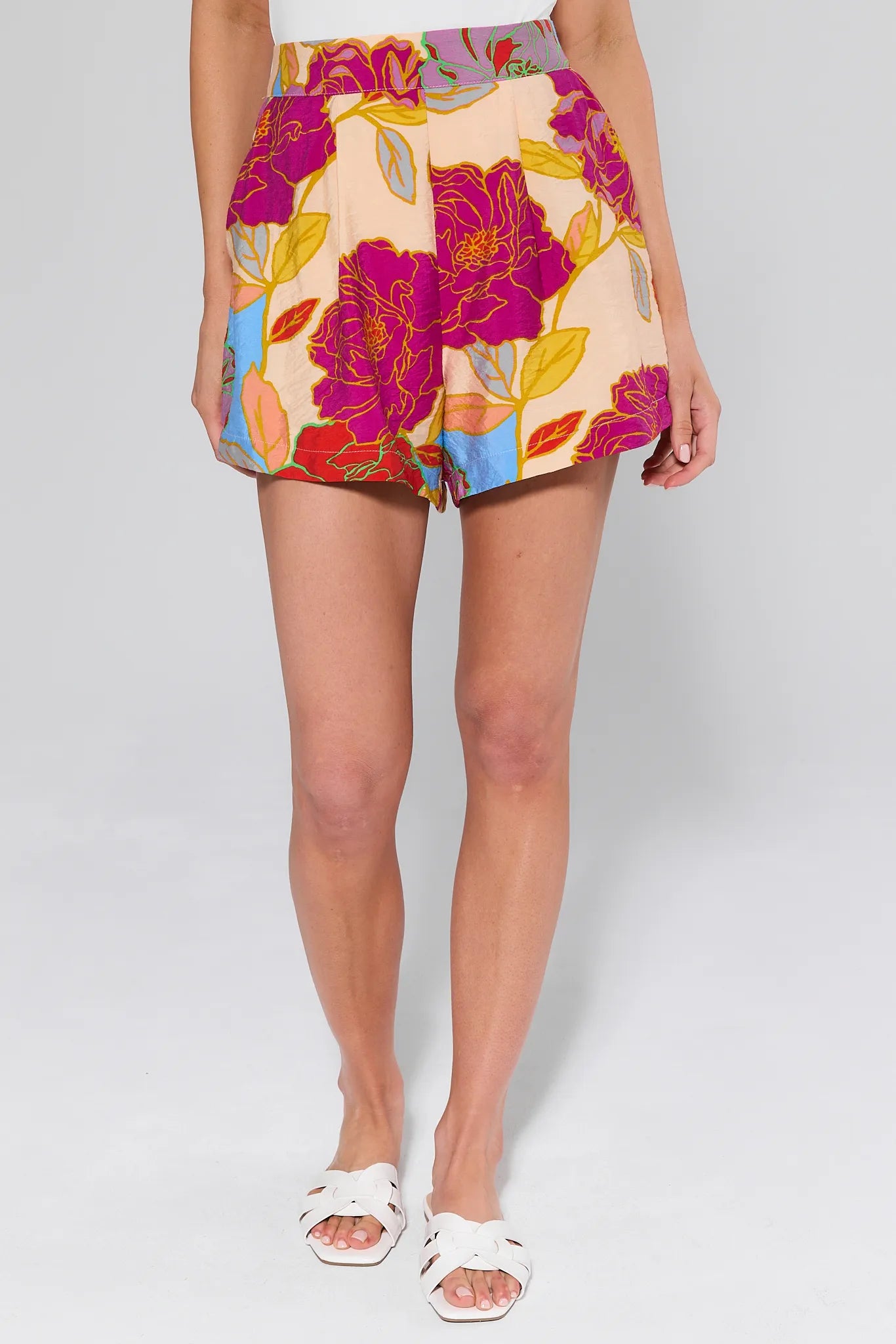Marisol Multicolor Floral Shorts and white flats worn by a person on a white background