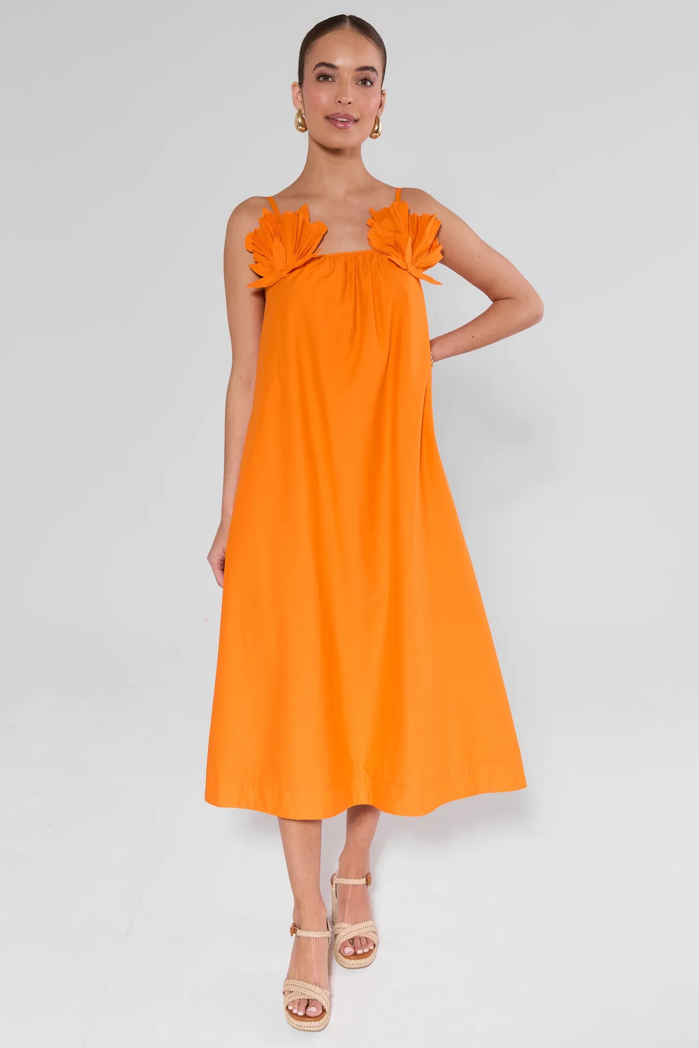 Woman wearing an Ariel Orange Shell Midi Dress with floral straps on a white background