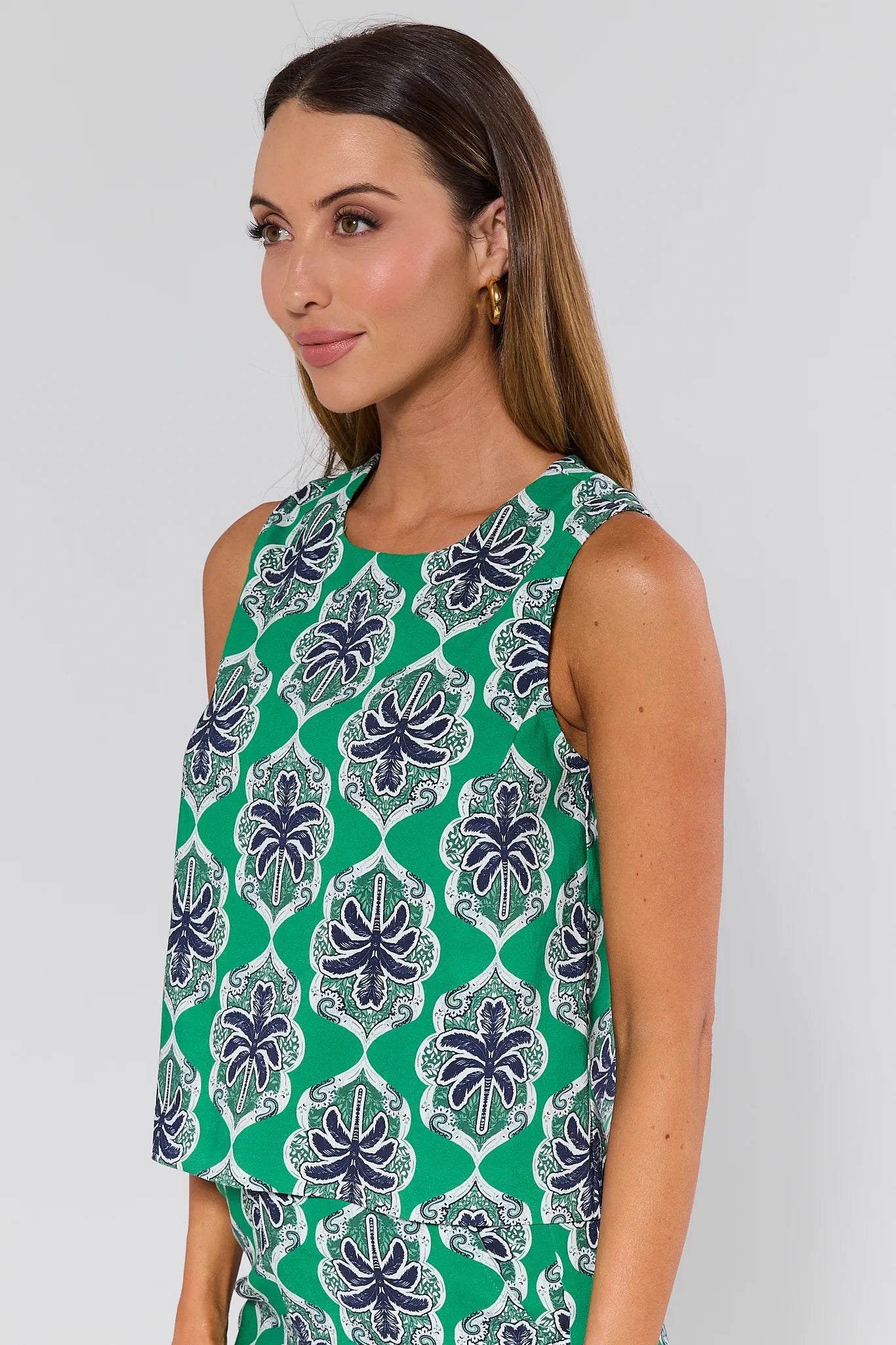 Woman wearing a green and blue patterned sleeveless top against a white background Goldie Green Printed Tank Top