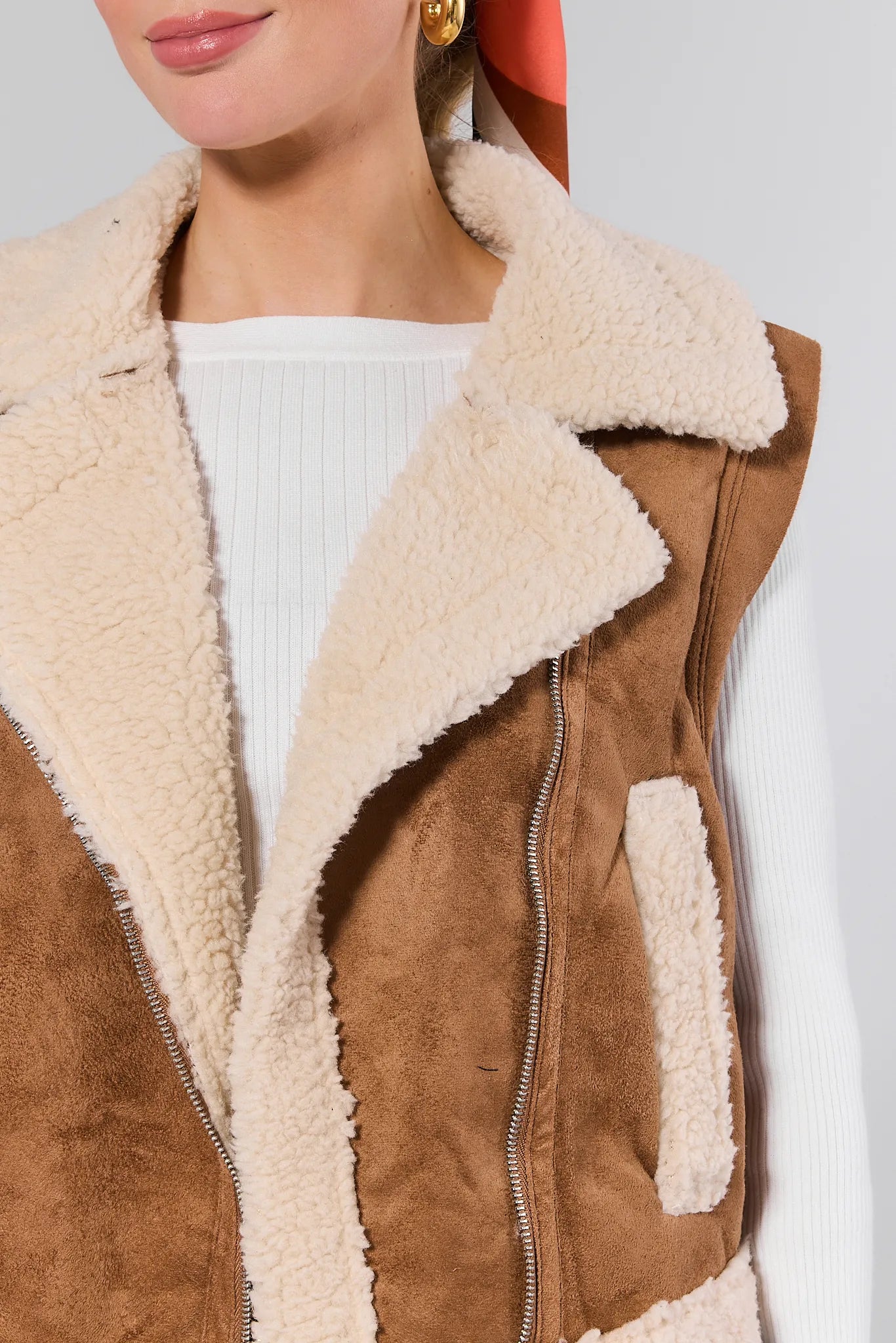 Brown suede Whitney Vest with beige sherpa lining worn by a person.