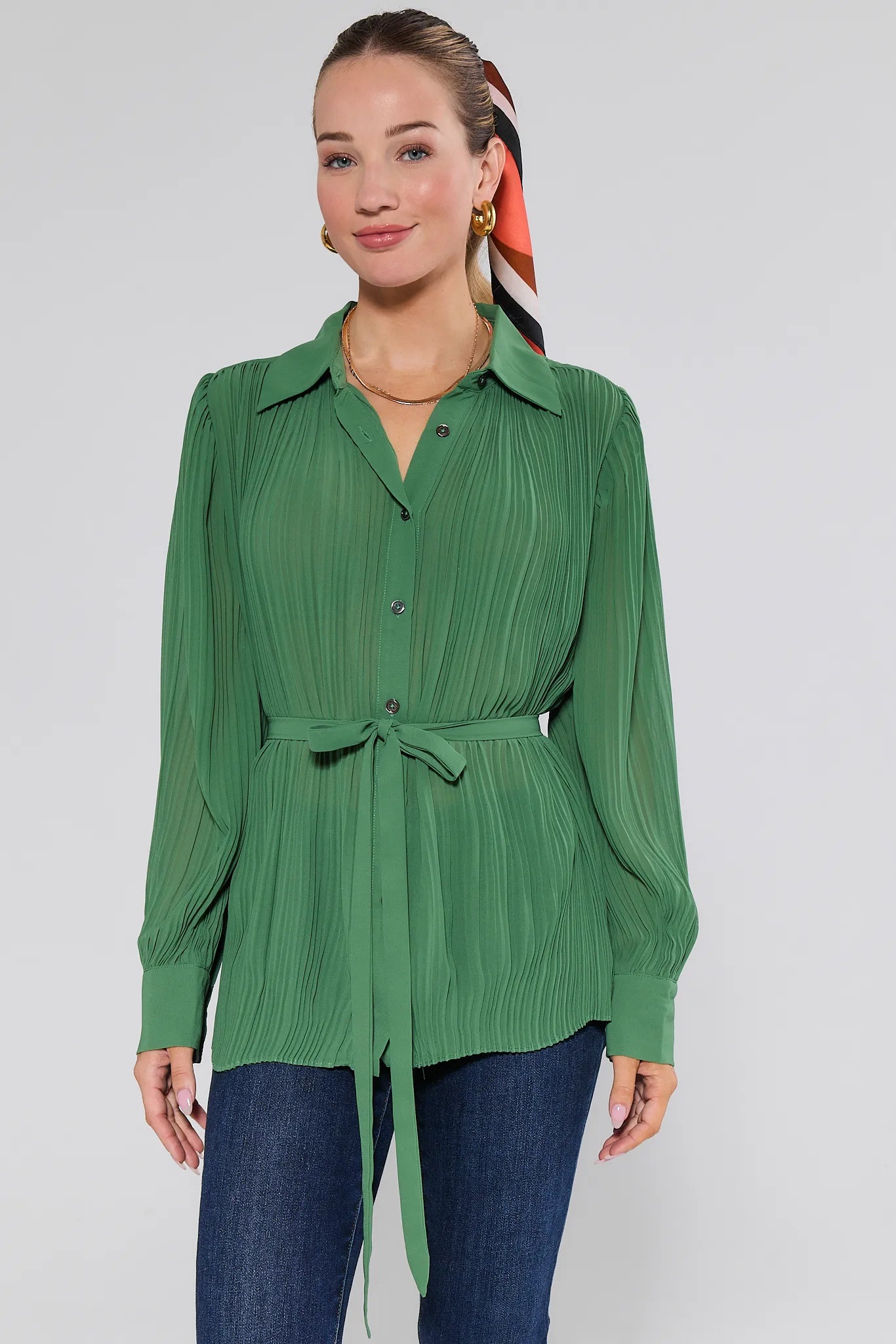 Woman wearing a green ribbed Miley Top with a tie waist against a white background