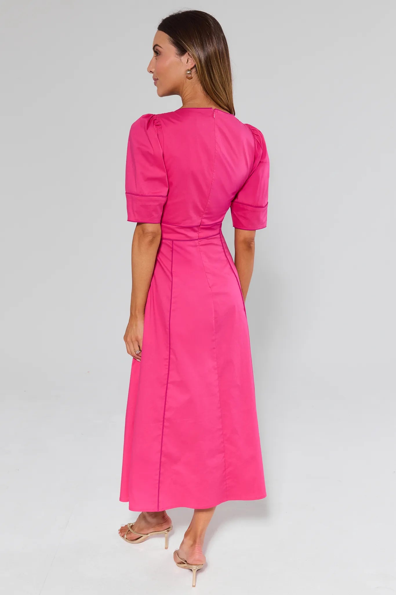 Woman wearing a Andrea Pink Maxi Dress and heels on a light gray background