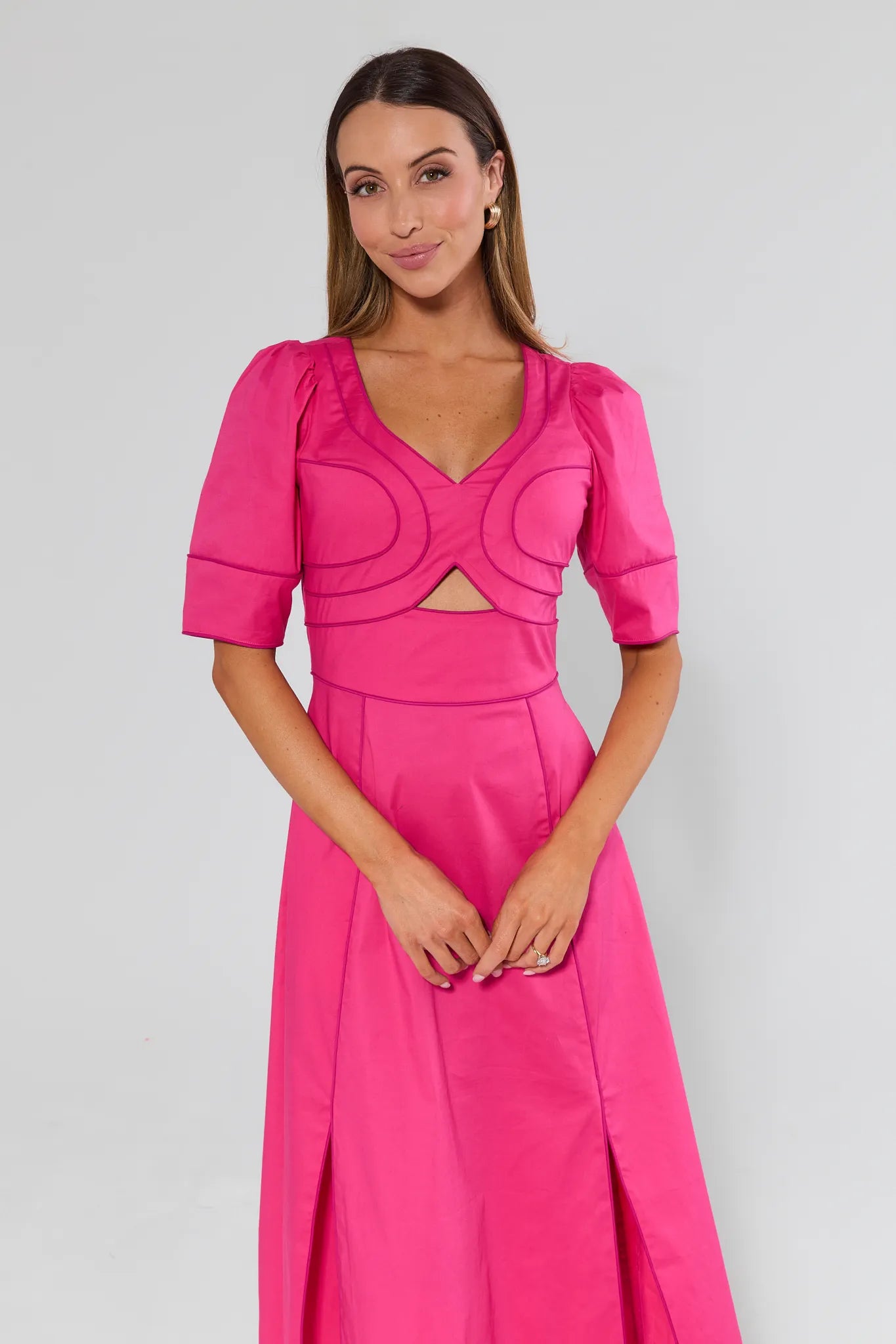 Woman wearing a Andrea Pink Maxi Dress with cut-out design on a plain background