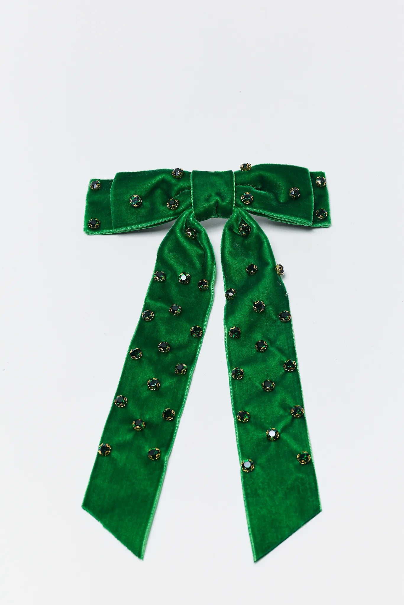 Green velvet bow with decorative elements on a light gray background