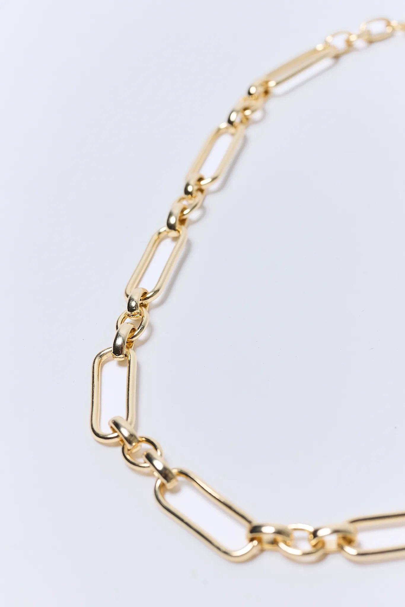 Gold chain Aster Necklace on a light gray background