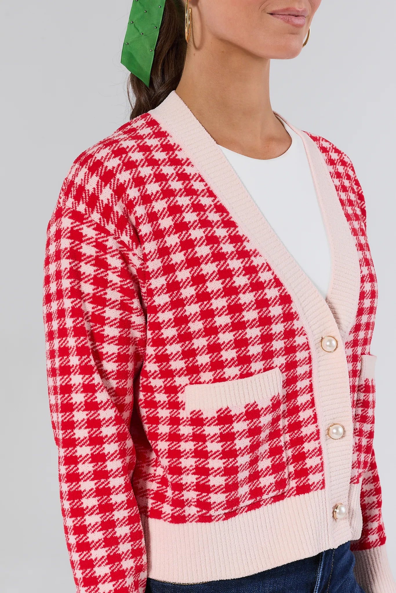 Red and white checkered cardigan worn by a person on a gray background