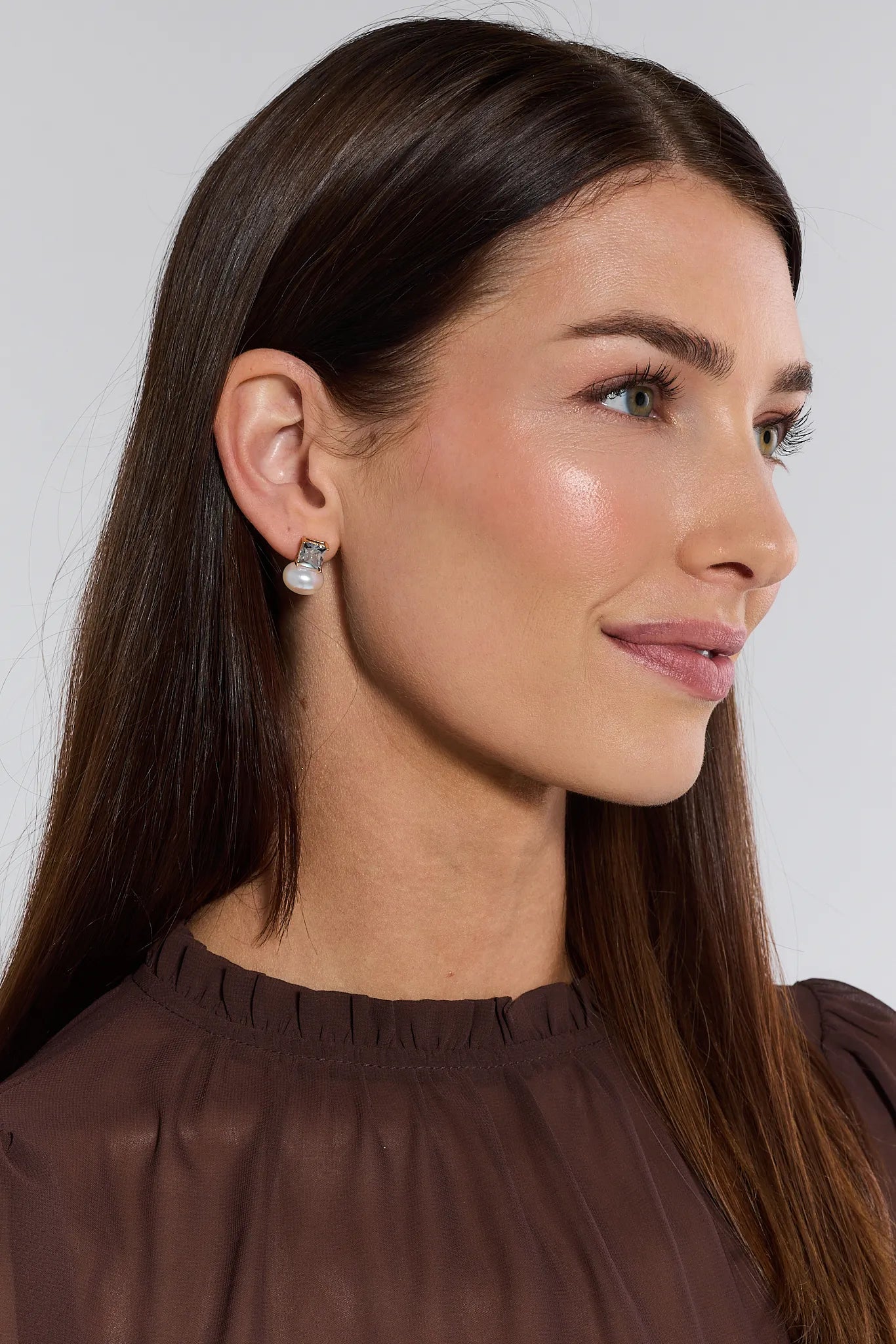 Woman wearing a brown top and Lucy Pearl and Crystal Earrings with a plain background
