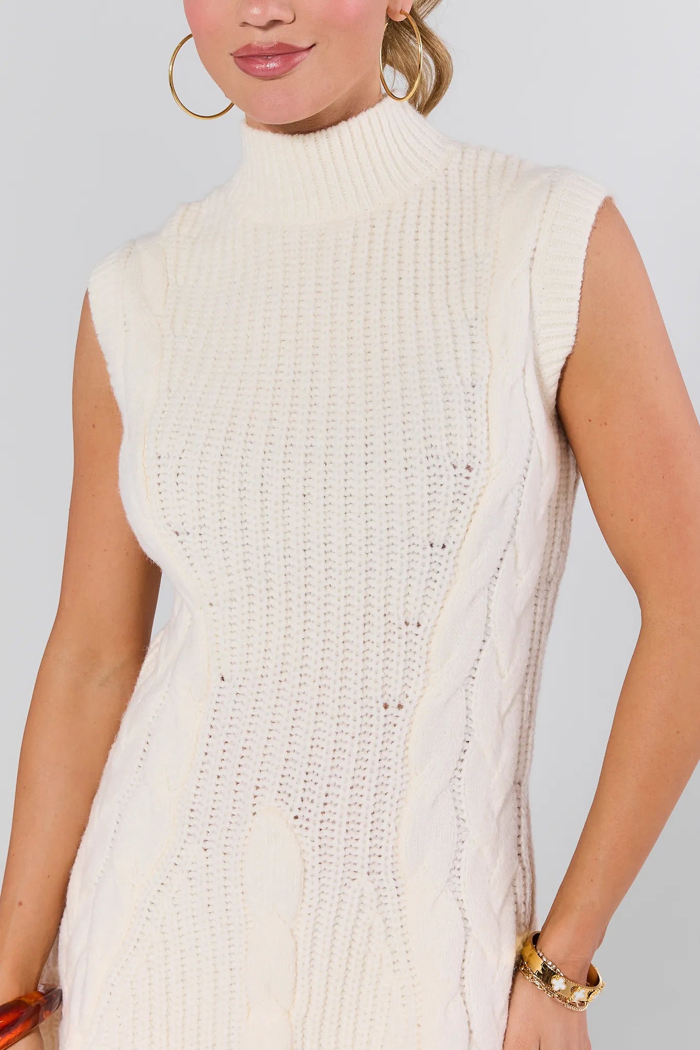 Woman wearing a Mila Ivory Knit Sweater Dress against a plain background