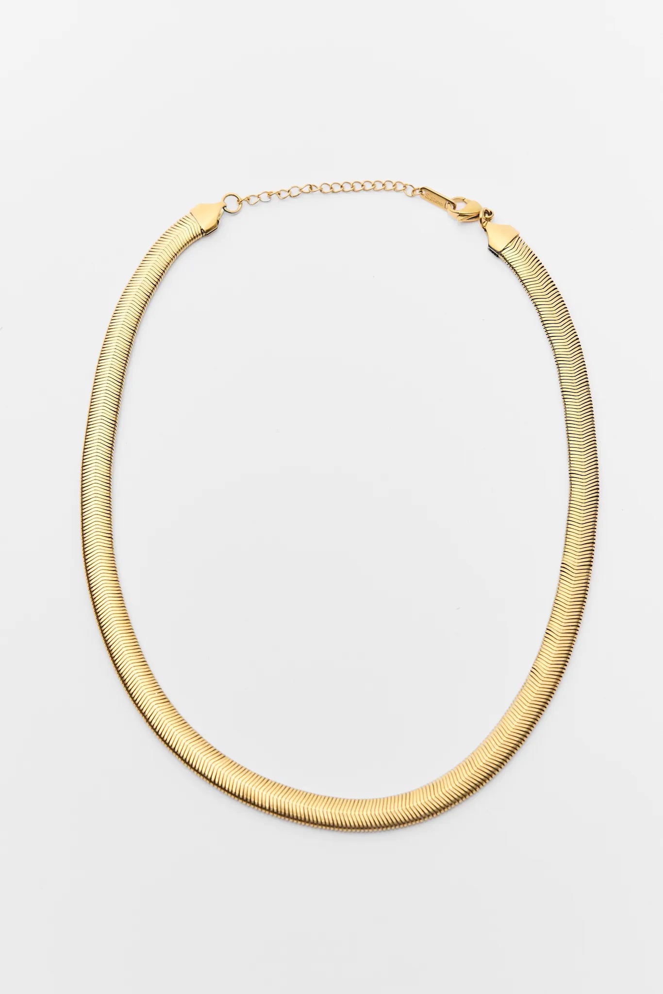 Gold necklace on a light gray background