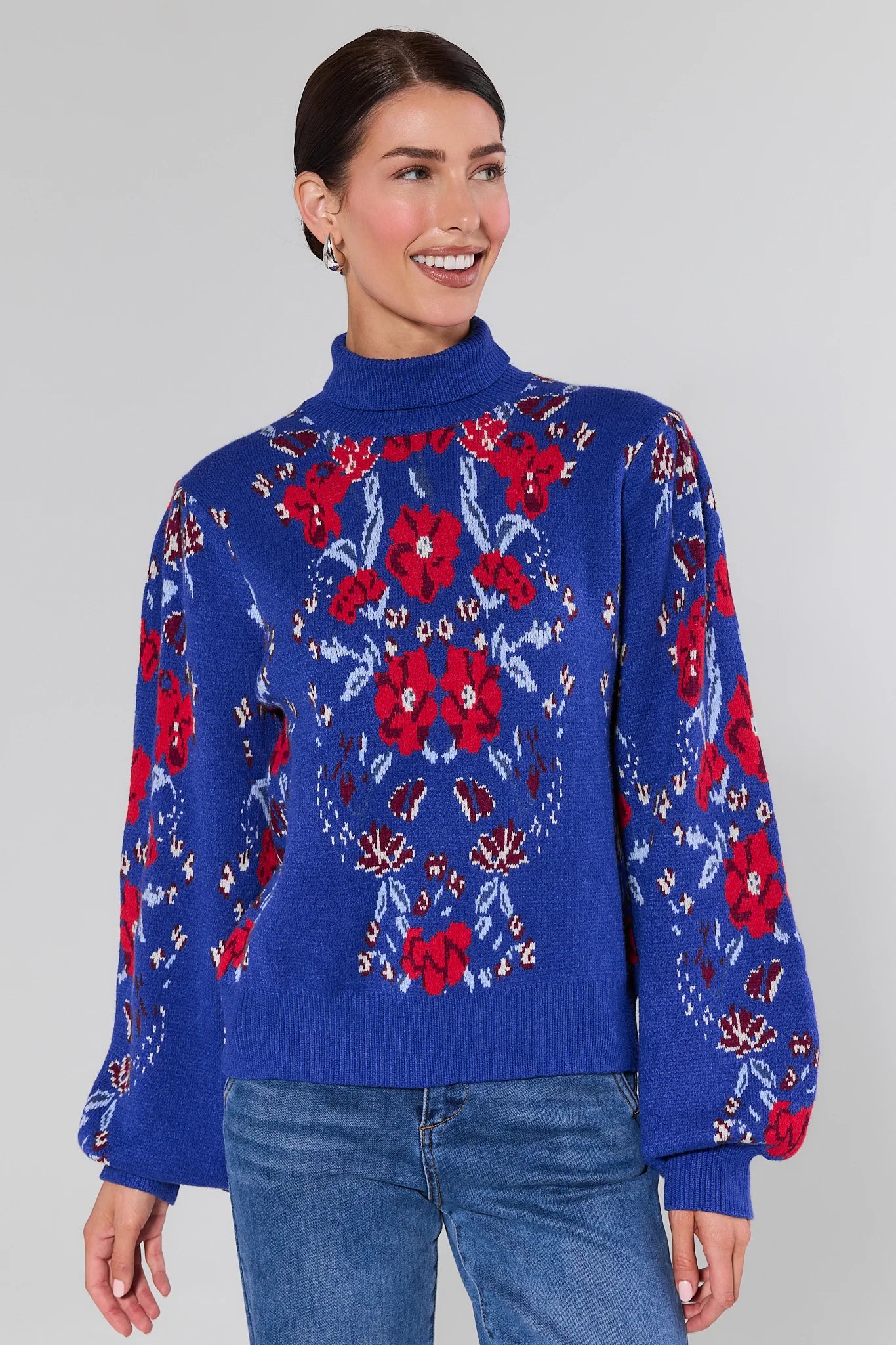Woman wearing a Loretta Blue Floral Knit Sweater on a plain background