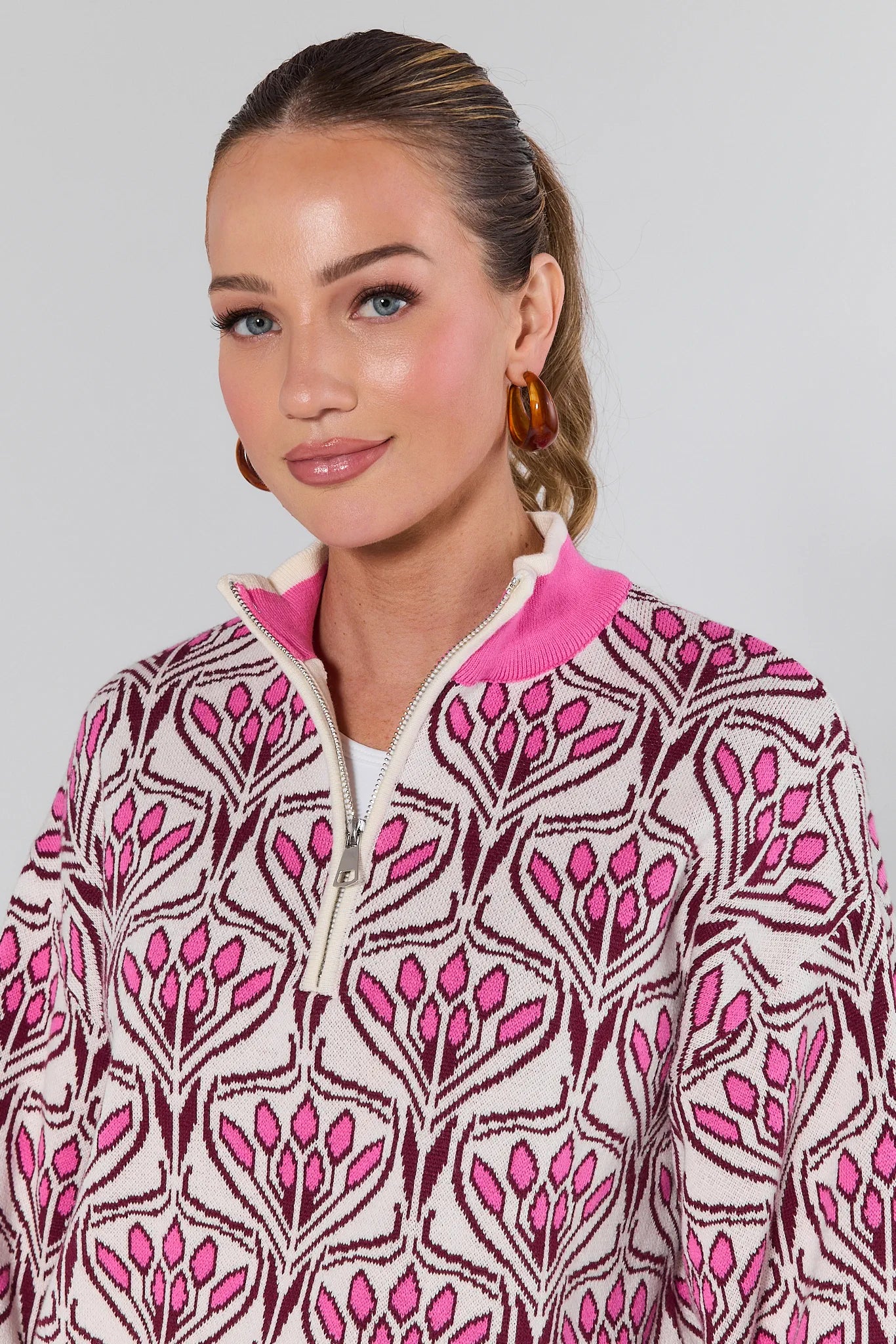 Woman wearing a Preston Pink Half Zip Sweater on a white background