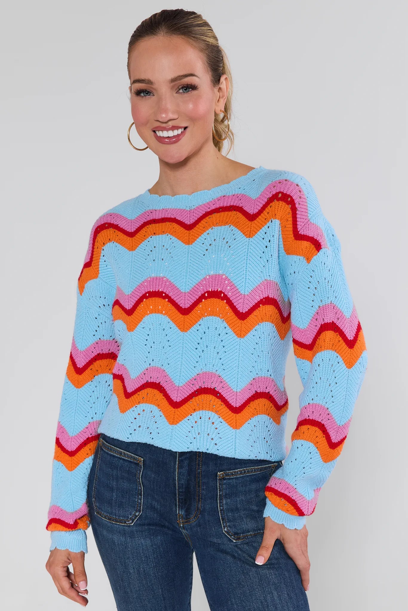 Woman wearing a Alice Multi Striped Scallop Sweater against a plain background