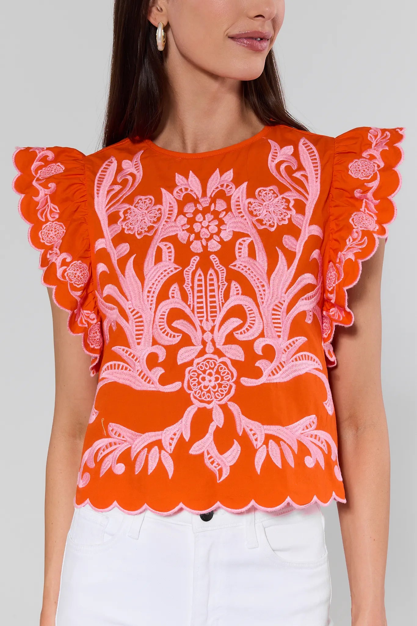 Orange lace top with ruffled sleeves on a plain background
