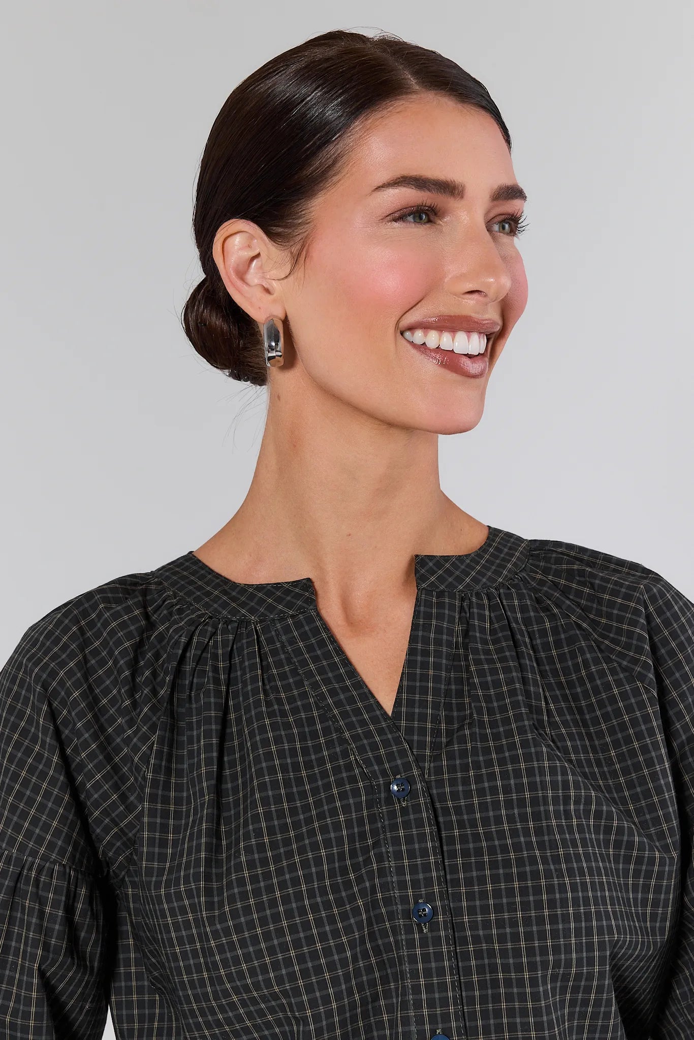 Woman wearing a Sammy Plaid Button Up Top and blue jeans against a plain background