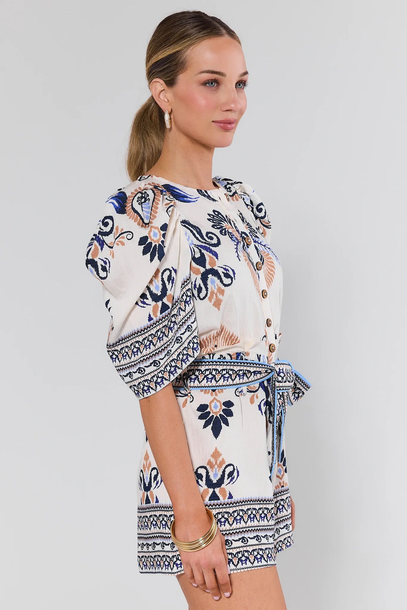 Woman wearing a patterned dress on a plain background