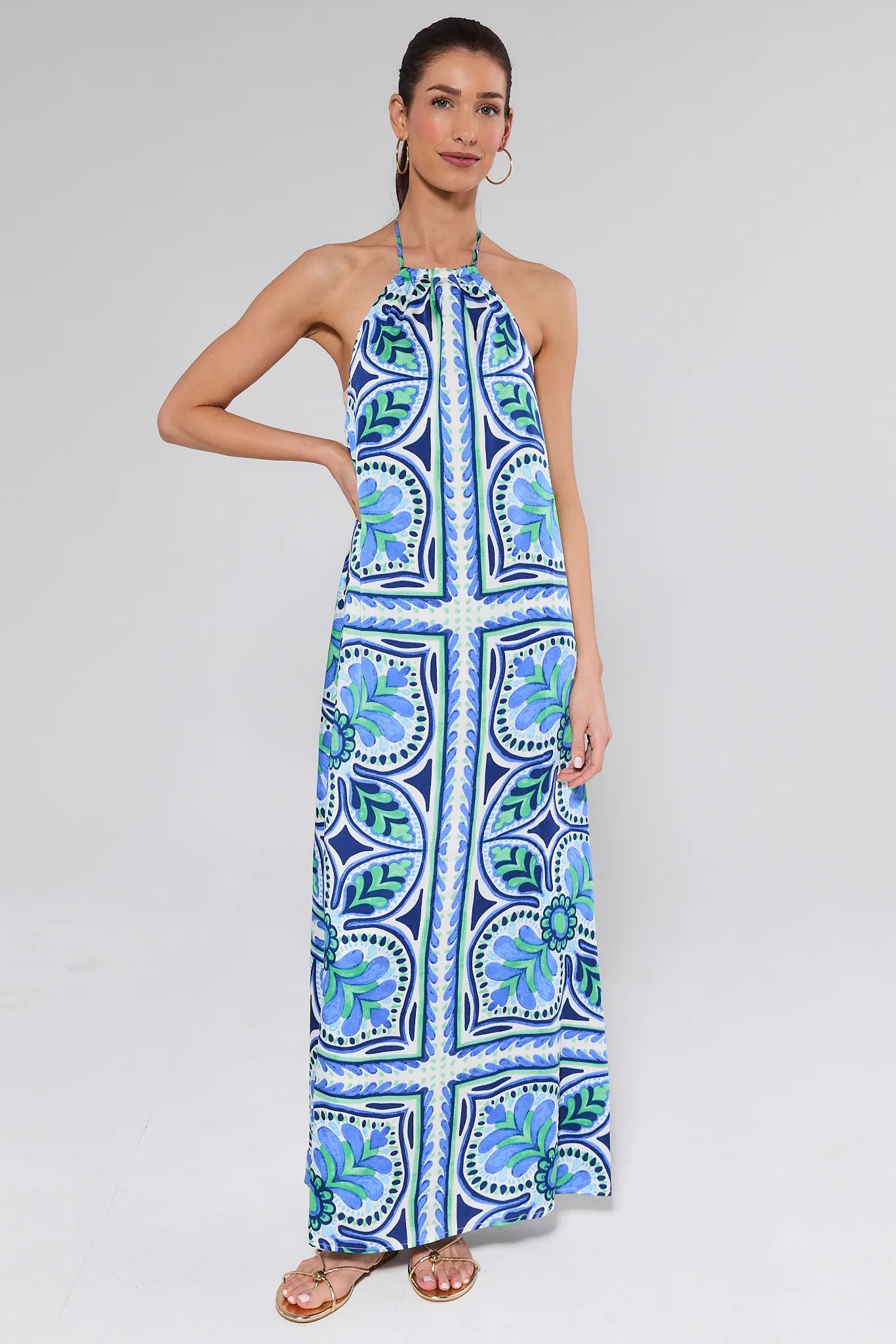 Woman wearing a blue and green patterned dress on a white background