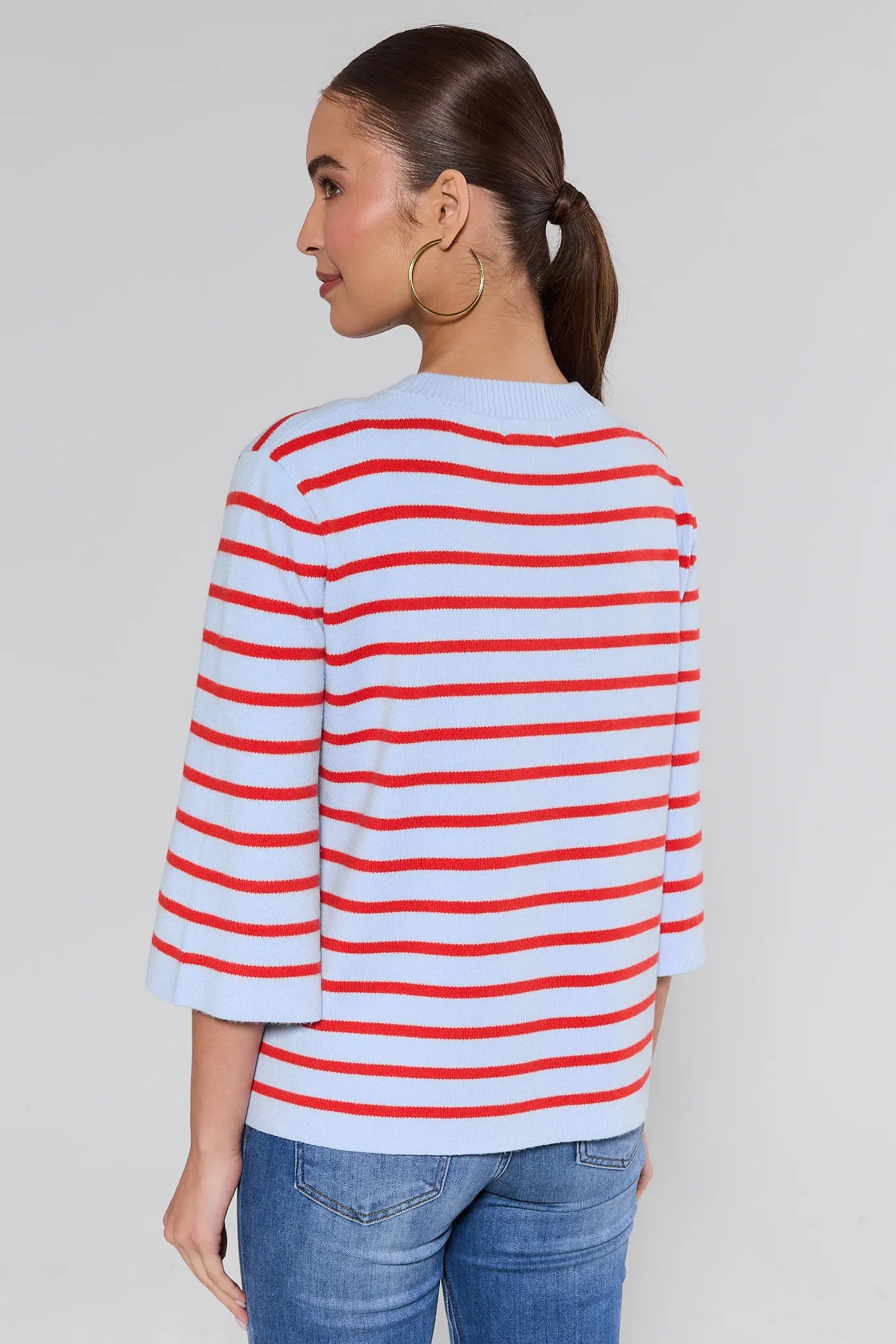 Woman wearing a red and white striped shirt against a plain background