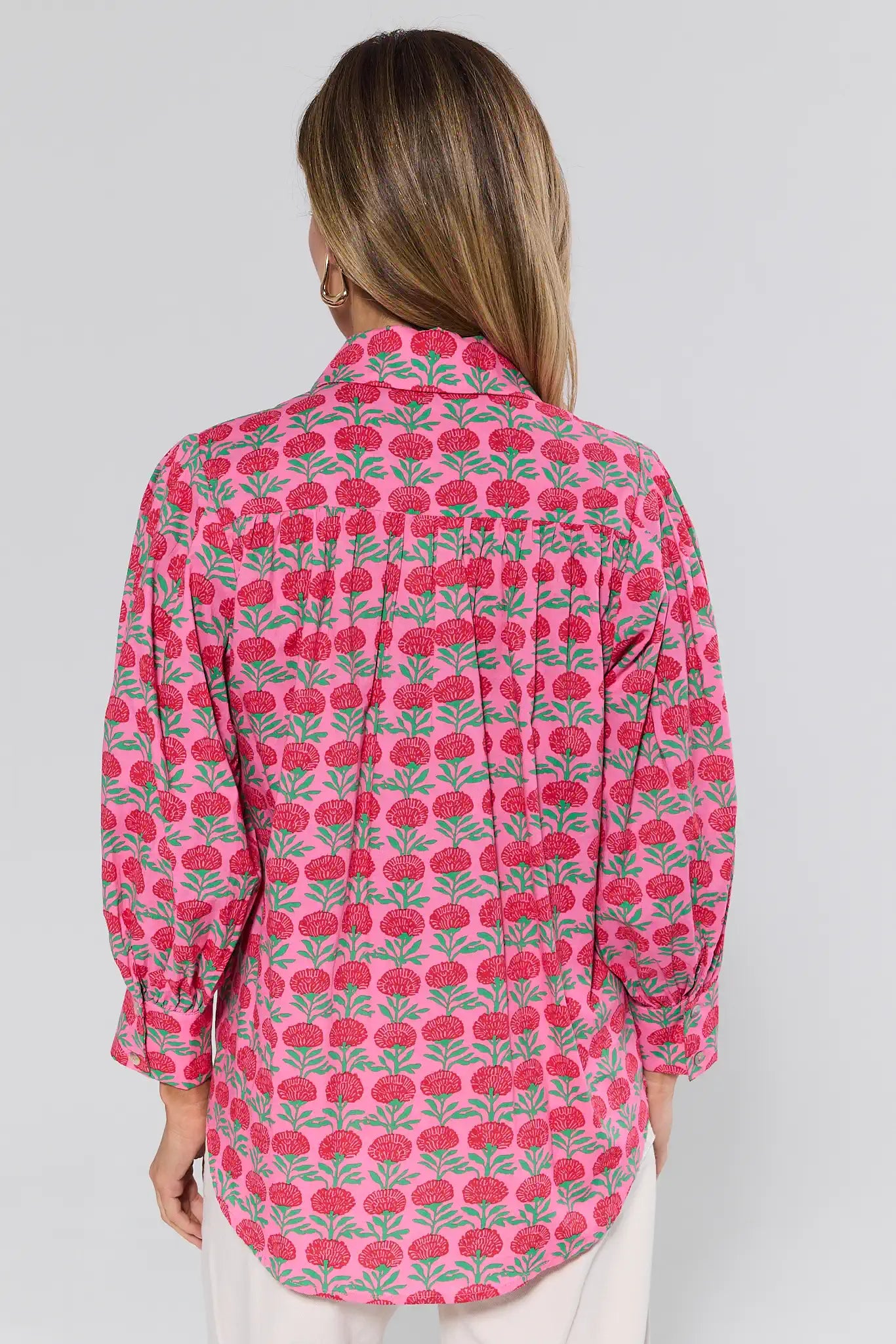 Woman wearing a pink floral patterned shirt on a white background